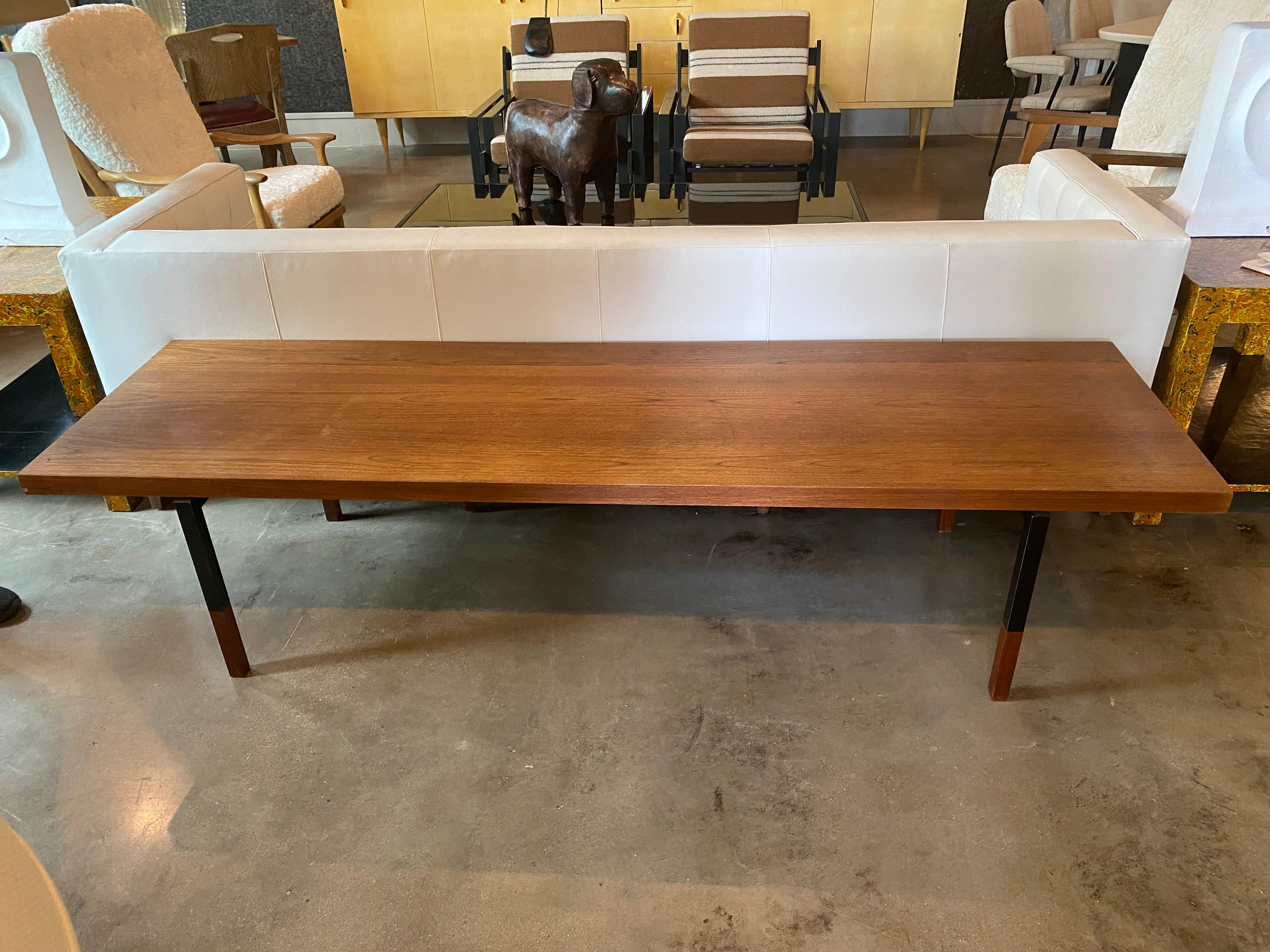 Elongated table or bench of Scandinavian mid-century styling. Teak or rosewood top with steel legs and wood feet. Denmark, 1950's.