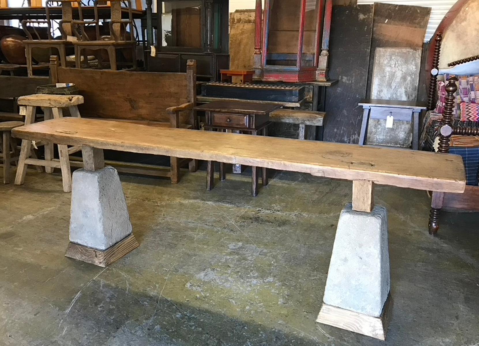 This console is made from an antique one wide board top which was originally a top for a Cofradia table (Guatemalan holy house table). The base consists of two antique stone bases, also Guatemalan. The table has been raised adding wood to the bottom