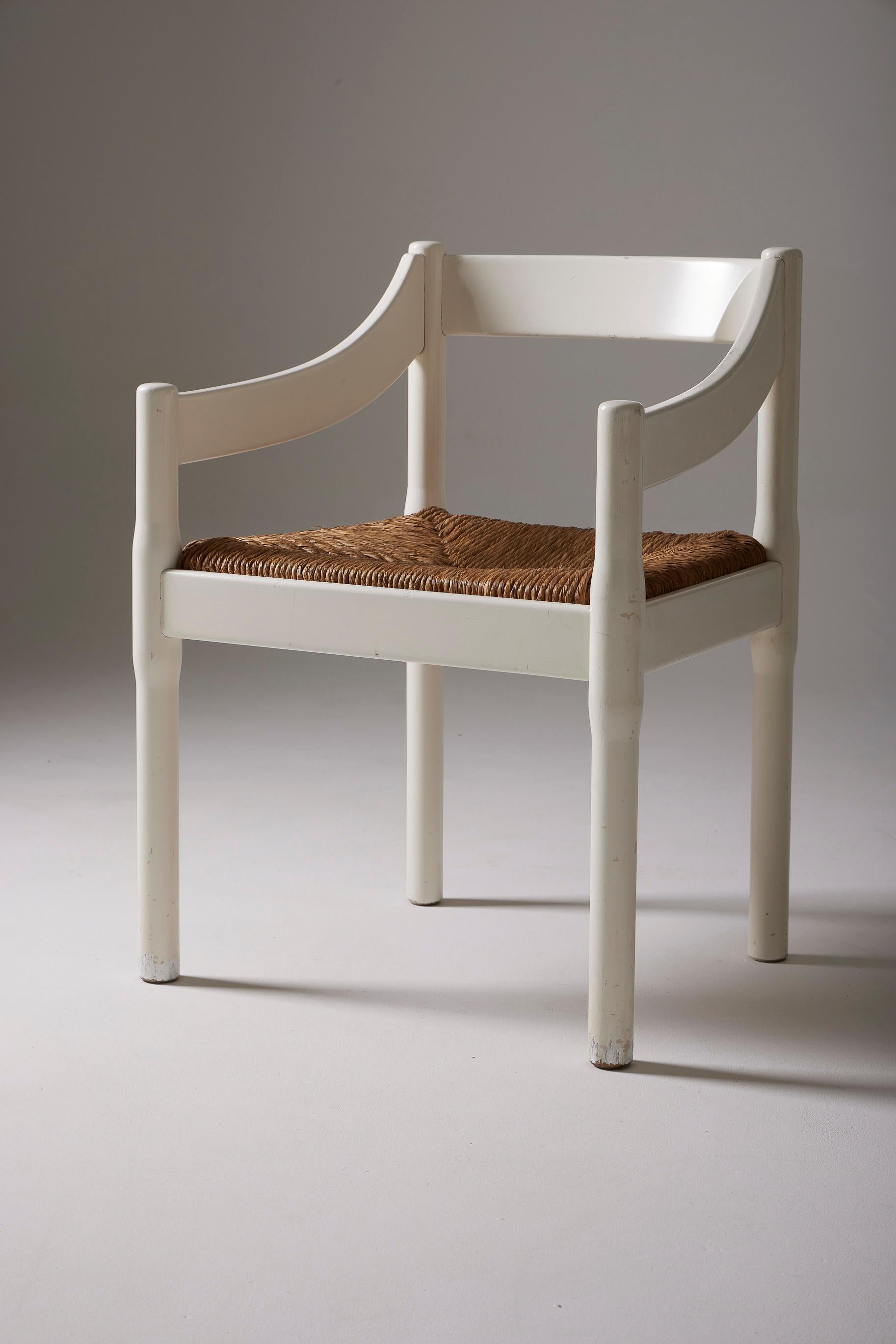 Modèle de chaise Carimate réalisé par le grand designer italien Vico Magistretti à la fin des années 1950 (1959). La structure de la chaise est en bois laqué blanc et l'assise est en paille. De discrètes marques d'usage ornent les meubles,