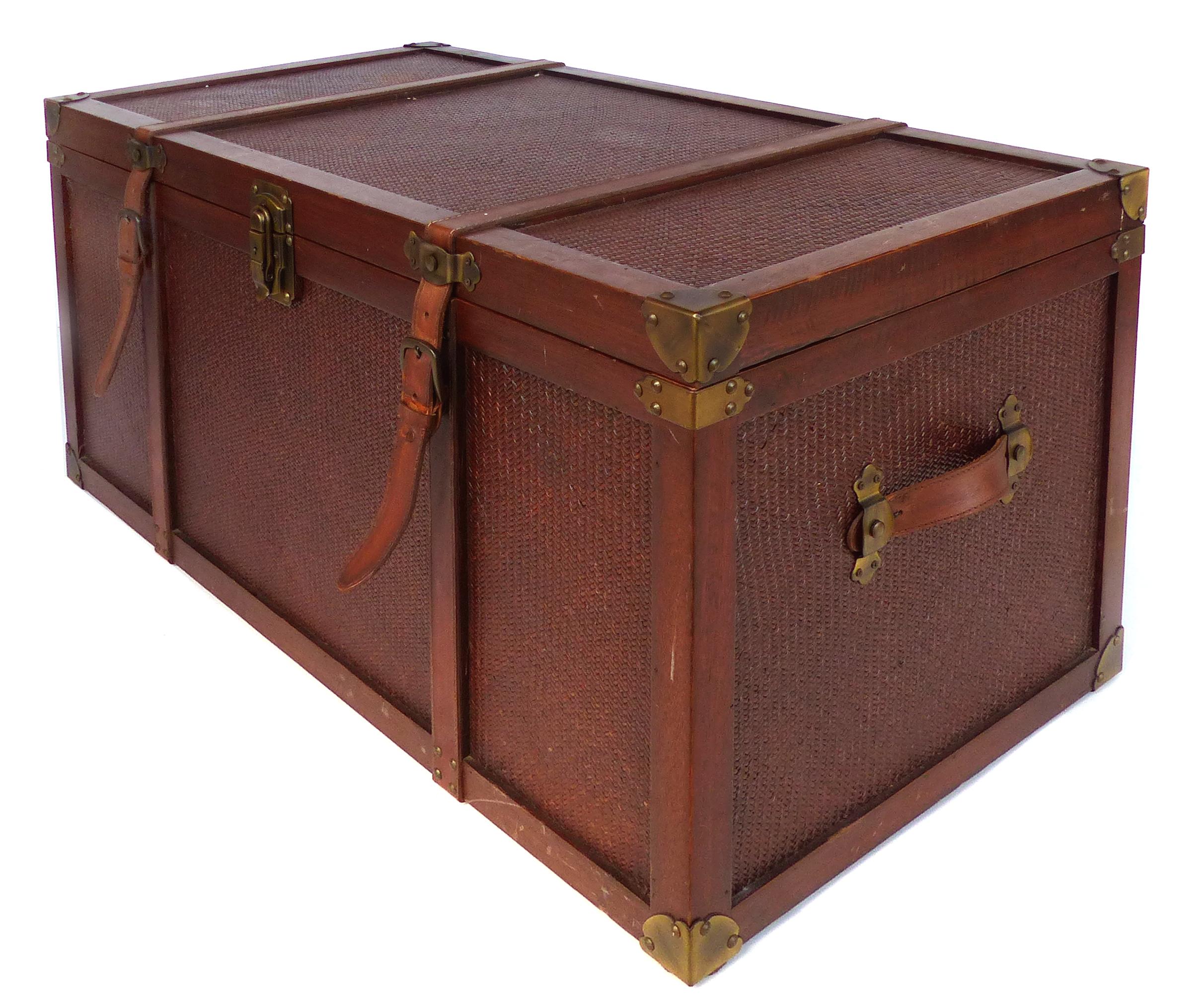 Offered for sale is a decorative blanket chest with woven reed inset panels. The trunk is framed in wood with brass corners and hardware as well a having leather straps handles on either end. The top surface shows vintage wear as depicted.