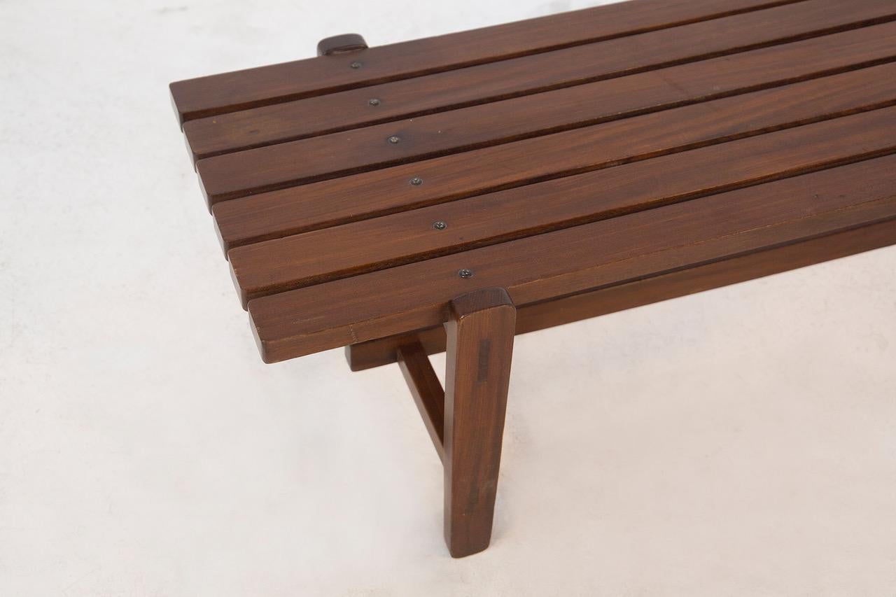 Precioso banco de madera diseñado por Ezio Longhi para Elam en 1950. El banco tiene seis listones de madera maciza de nogal. La línea clásica hace que el banco de Ezio Longhi sea perfecto para ambientes refinados y con clase, como salones o zonas de