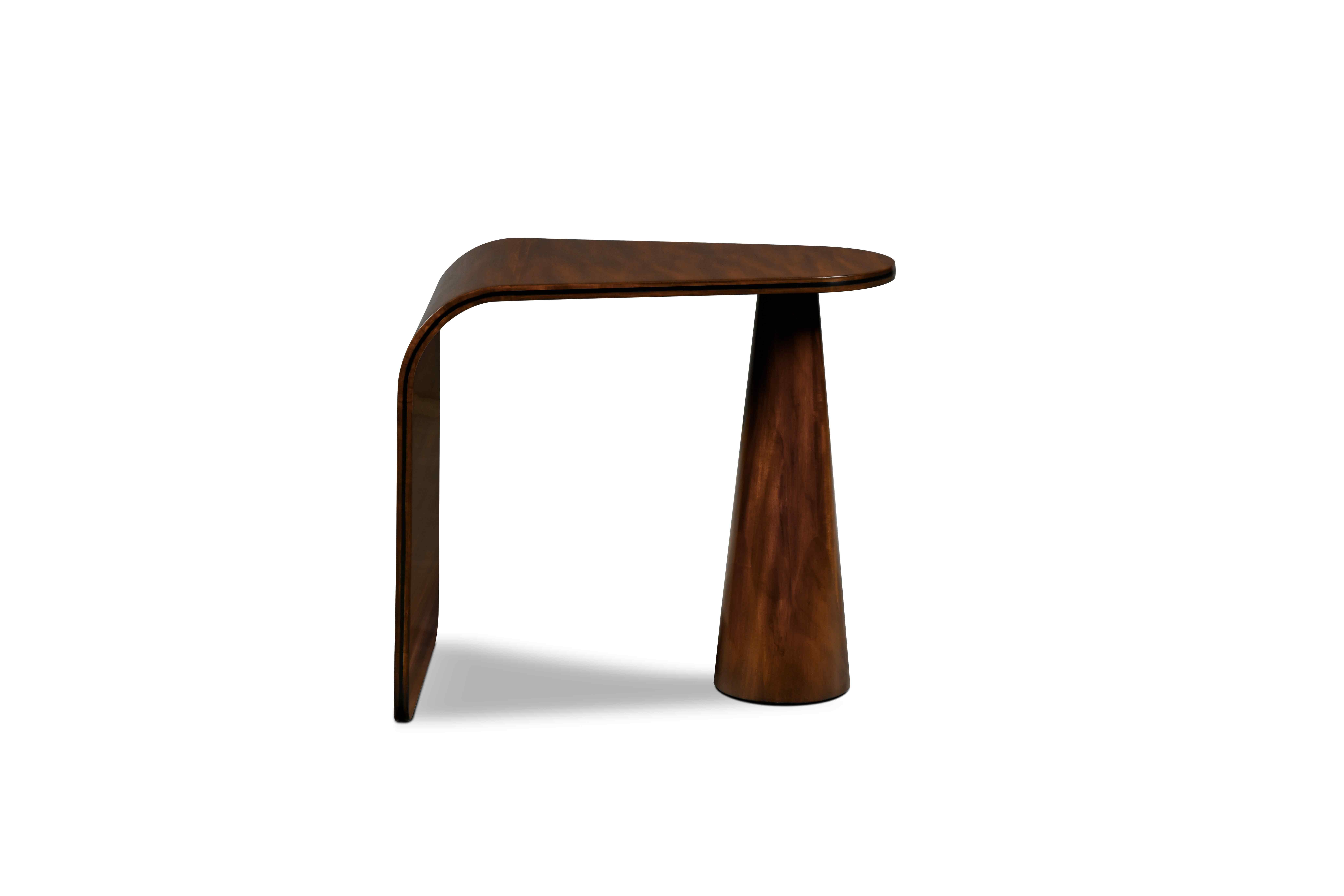 Esta moderna mesa auxiliar es una delicia visual. Tiene una base cónica lisa, y el tablero se extiende hasta el suelo con una curva continua hacia abajo. Tiene el elegante detalle de una incrustación metálica en el borde del tablero.

