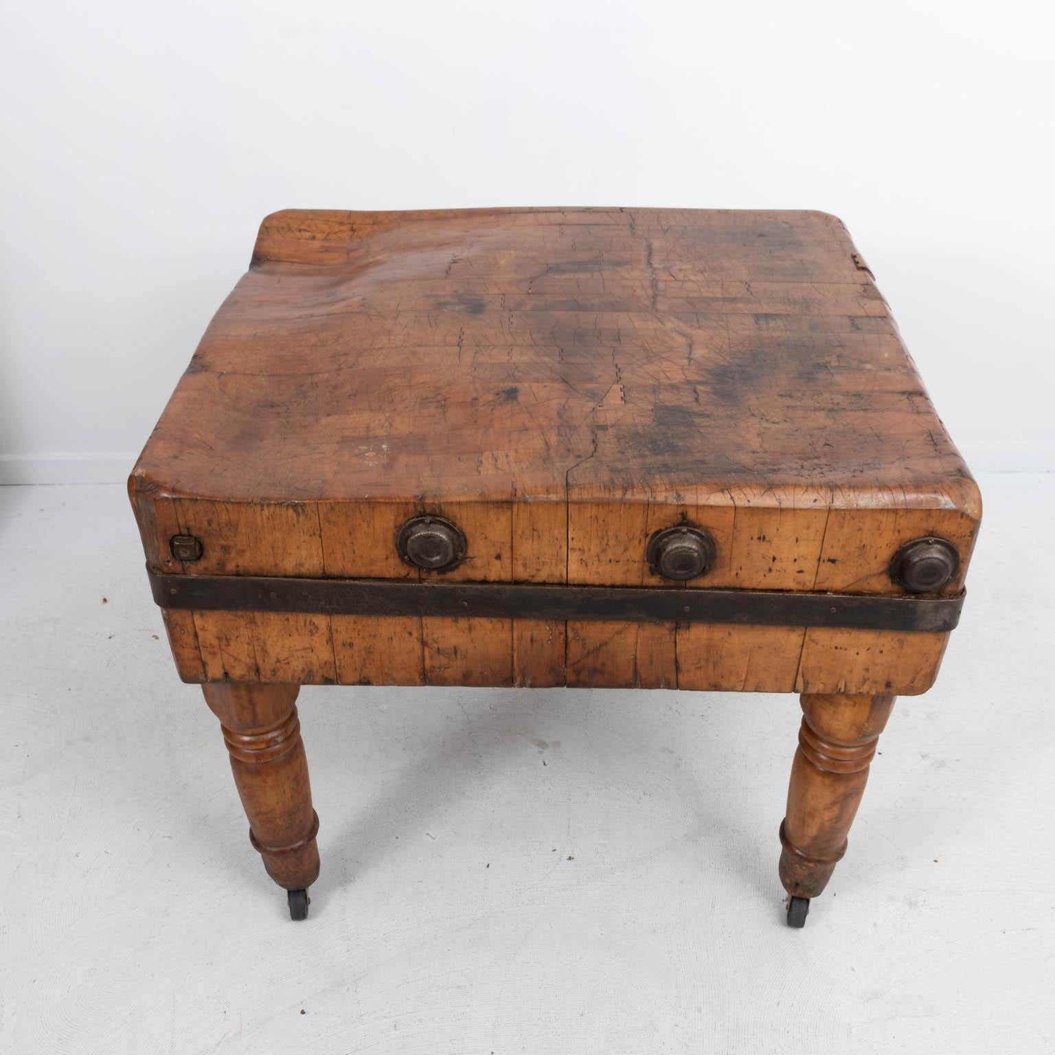 Wood butcher's block table by John Boos and Company Manufacturer on casters. Please note of wear consistent with age including patina and oxidation to the metal. There is also heavy wood loss, chips, dents, and wear throughout due to daily use