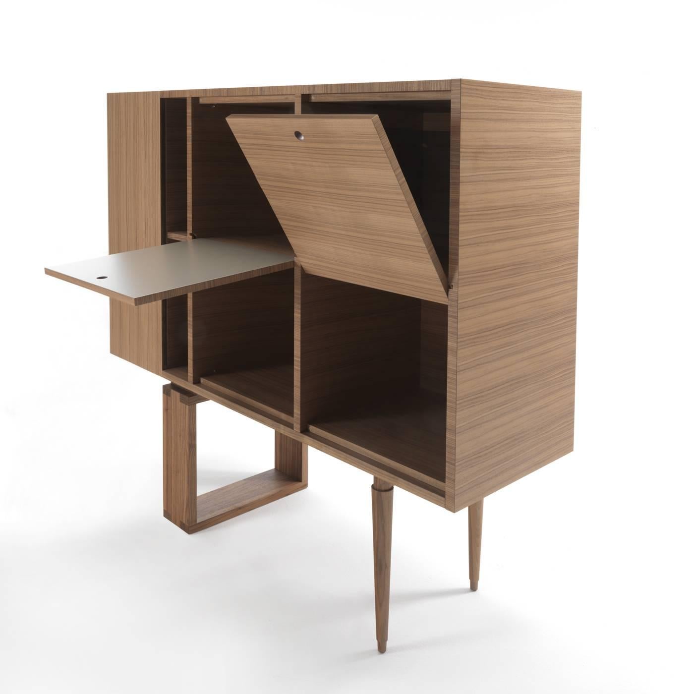 This striking cabinet features a vertical side container on the left with a narrow double shelf next to it. The central space is divided into four quadrants that liberally move with doors that can be flipped open thanks to an ingenious joint secured