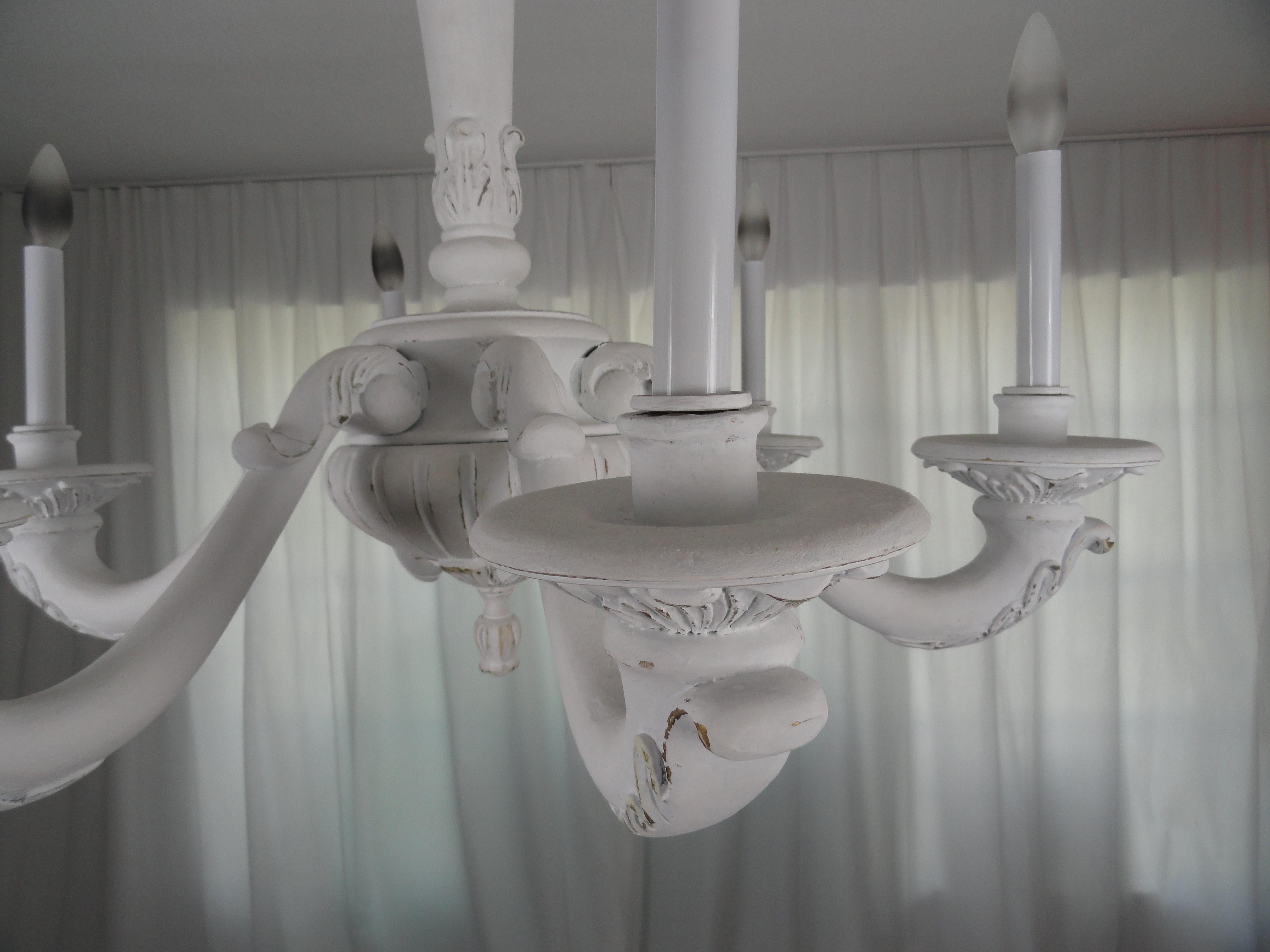Six-light wood carved chandelier with white rubbed finish.