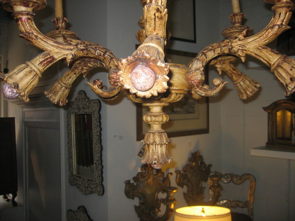Beautifully hand carved 6-light chandelier with original gilding and antiqued paint finish.