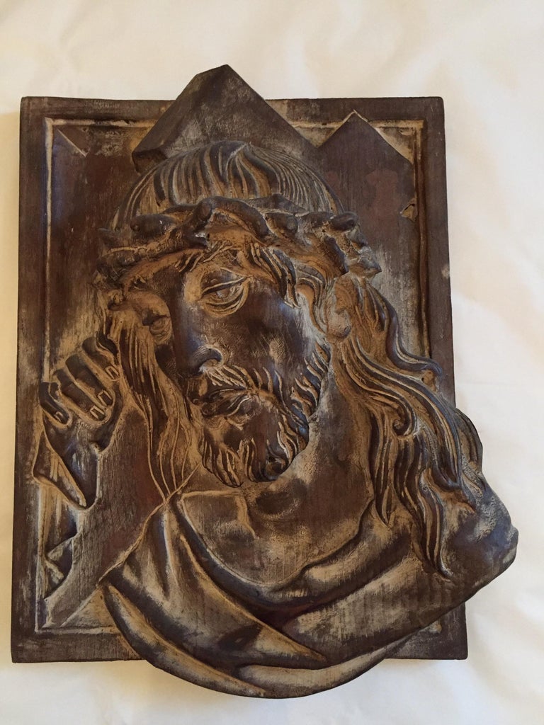 A vintage deeply carved Cembran pinewood Christ Head bas-relief, a religious wall hanging panel depicting a Christ head wearing thorns and holding cross. Original decapé finish, material is original of the period and thus shows normal signs of age