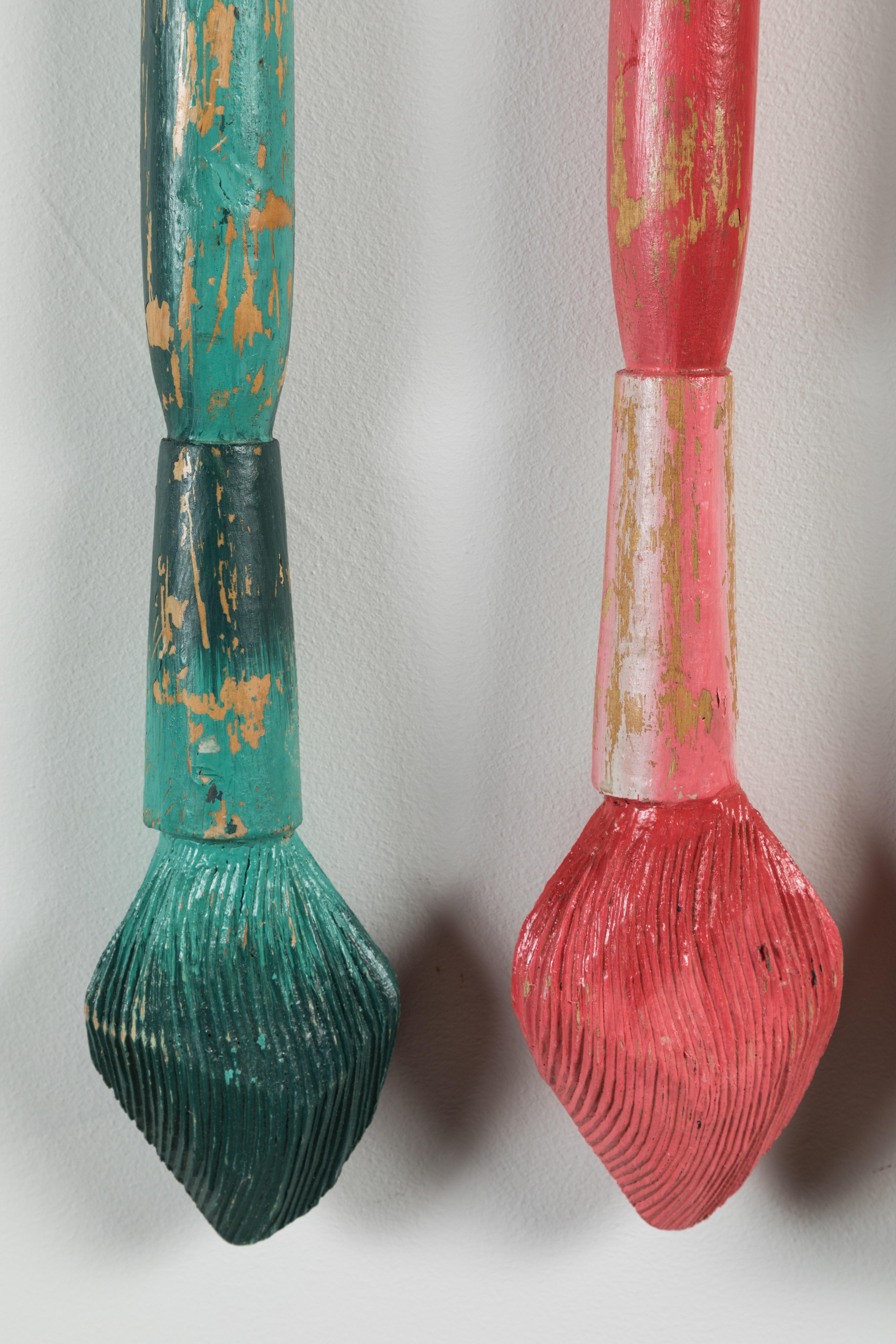 Fantastic hand carved giant wood artist paintbrushes. All original multi colored paint surface. Completely wood carved. Perhaps part of a retail window display or a trade sign. Great American Folk Art. Includes four carved paint brushes and custom