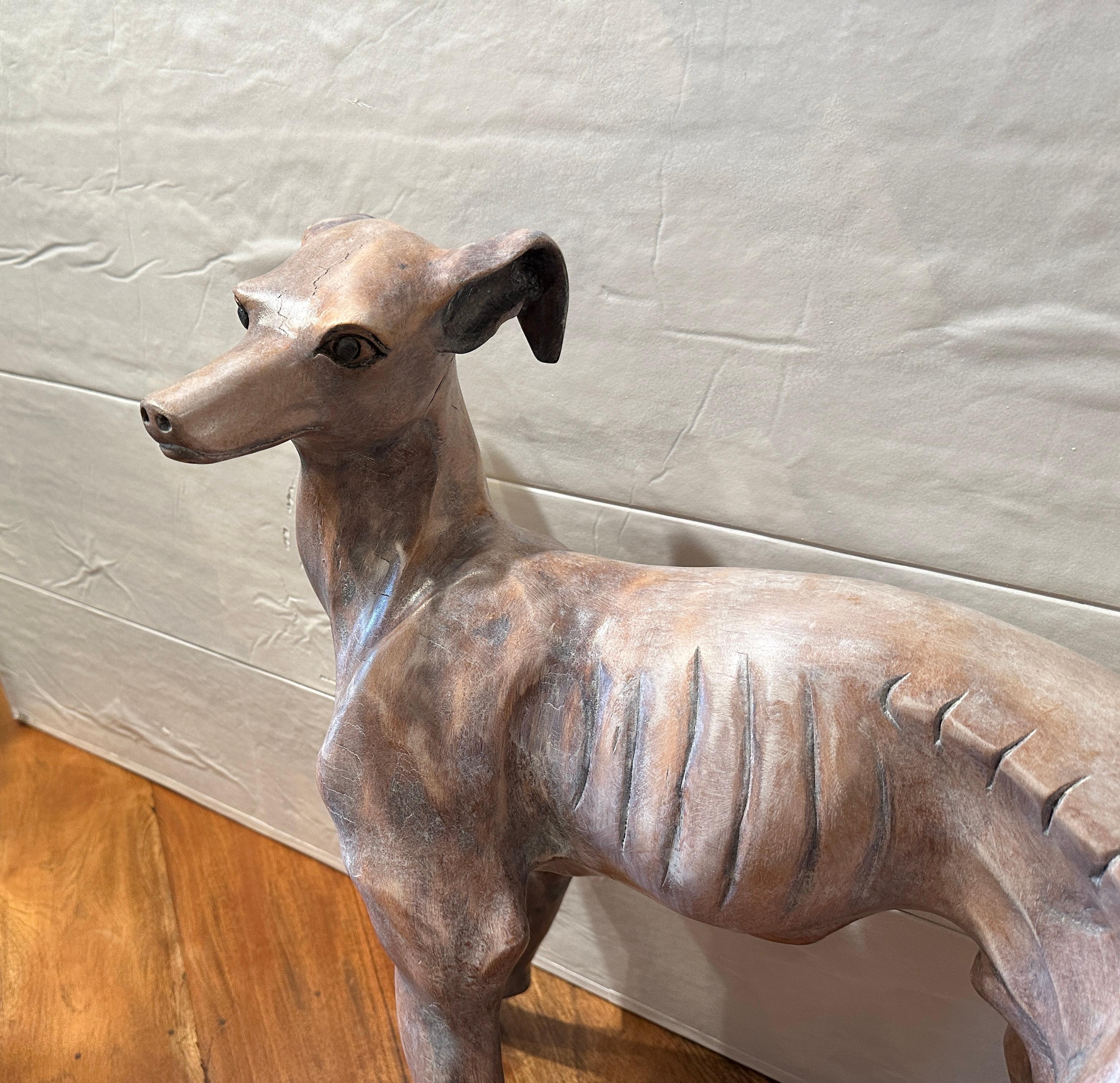 Beautifully hand carved in wood, standing Whippet dog.  Face is exquisitely carved as well as the rest of the figure.  Dove gray wash make it almost real.
Wonderful condition exception of small chip on the toe.