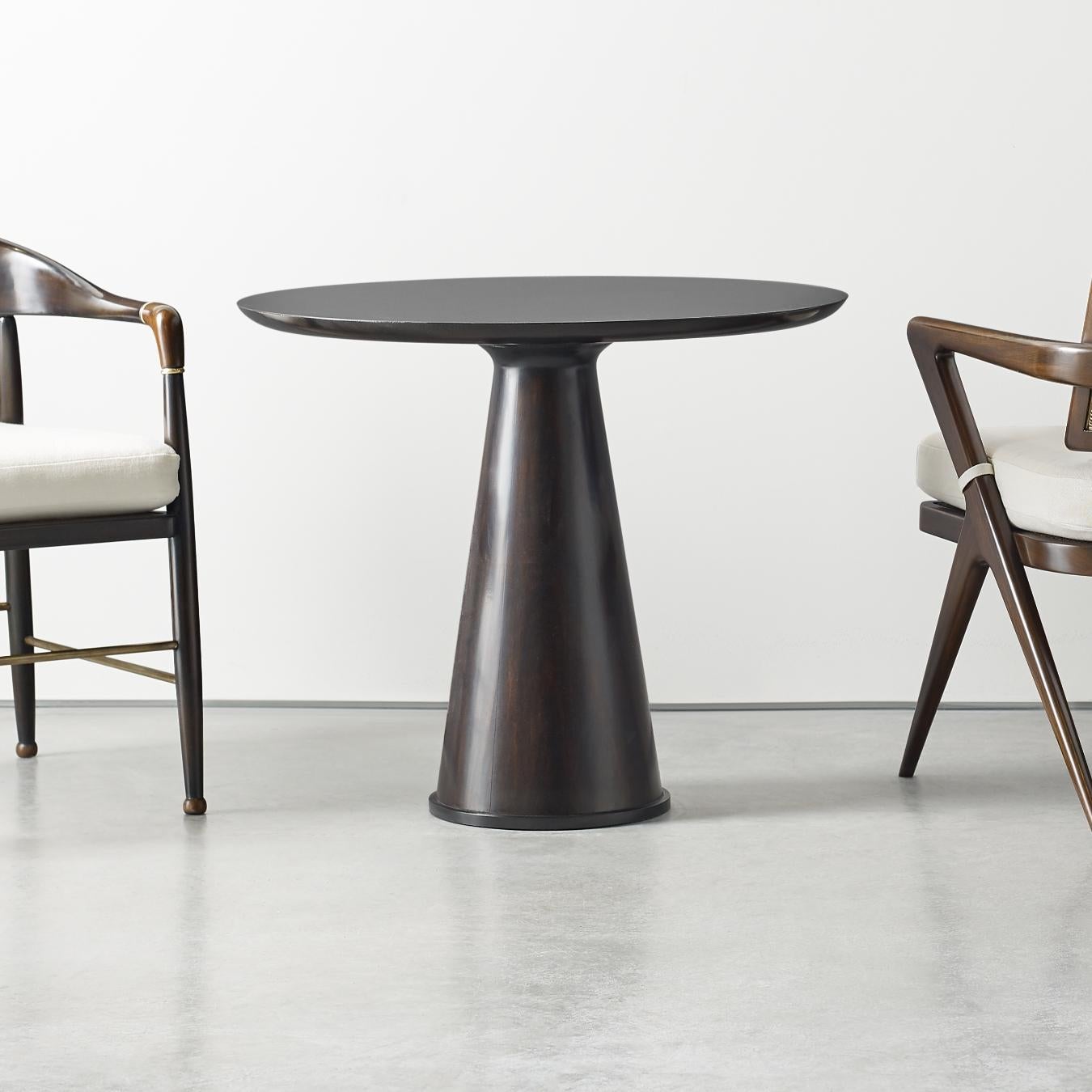 This circular occasional table with a conic base is perfect for any setting and comes in two different finishes.
 