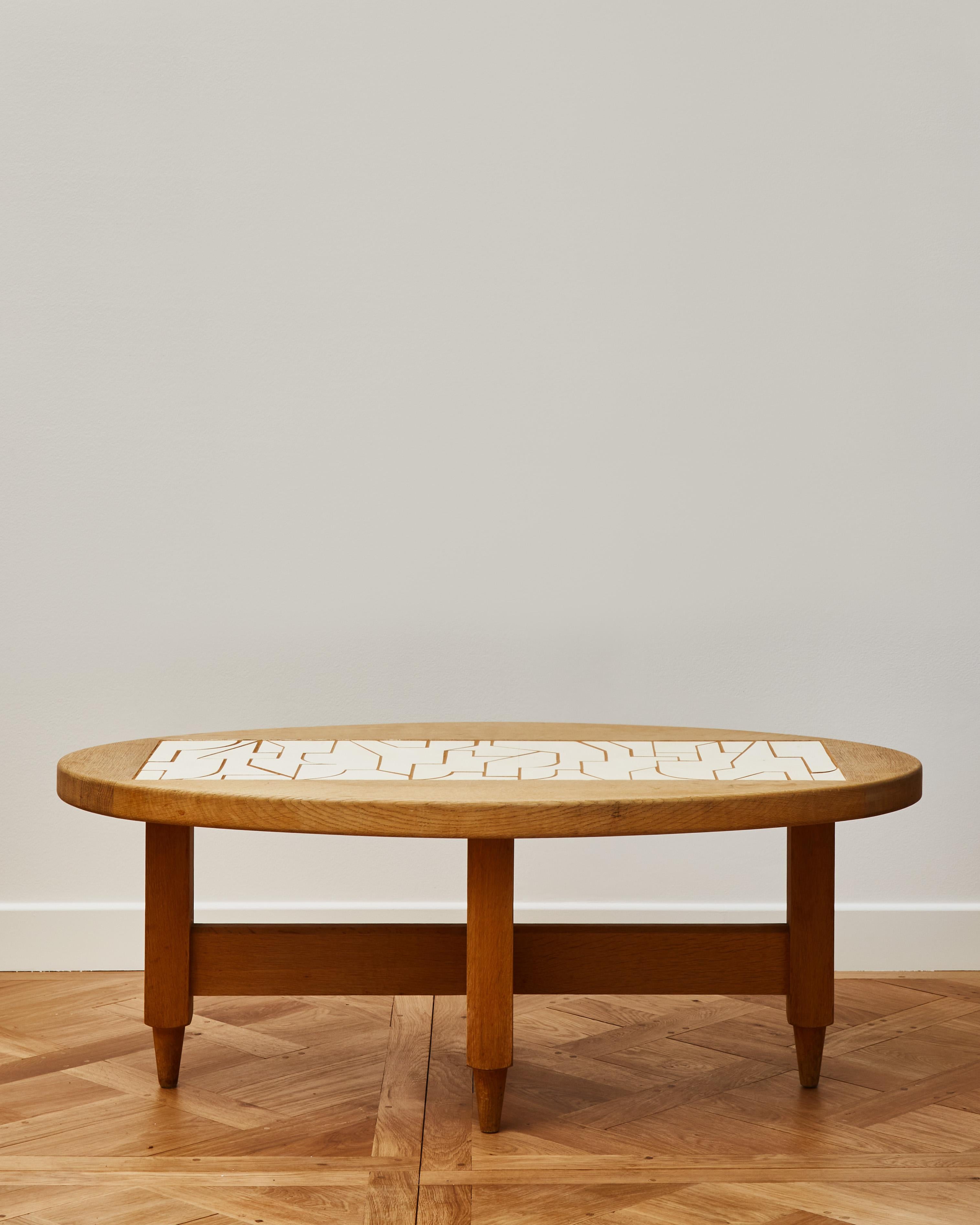 Oval shaped oak coffee table with white ash inlay by the French maker François Weiss.