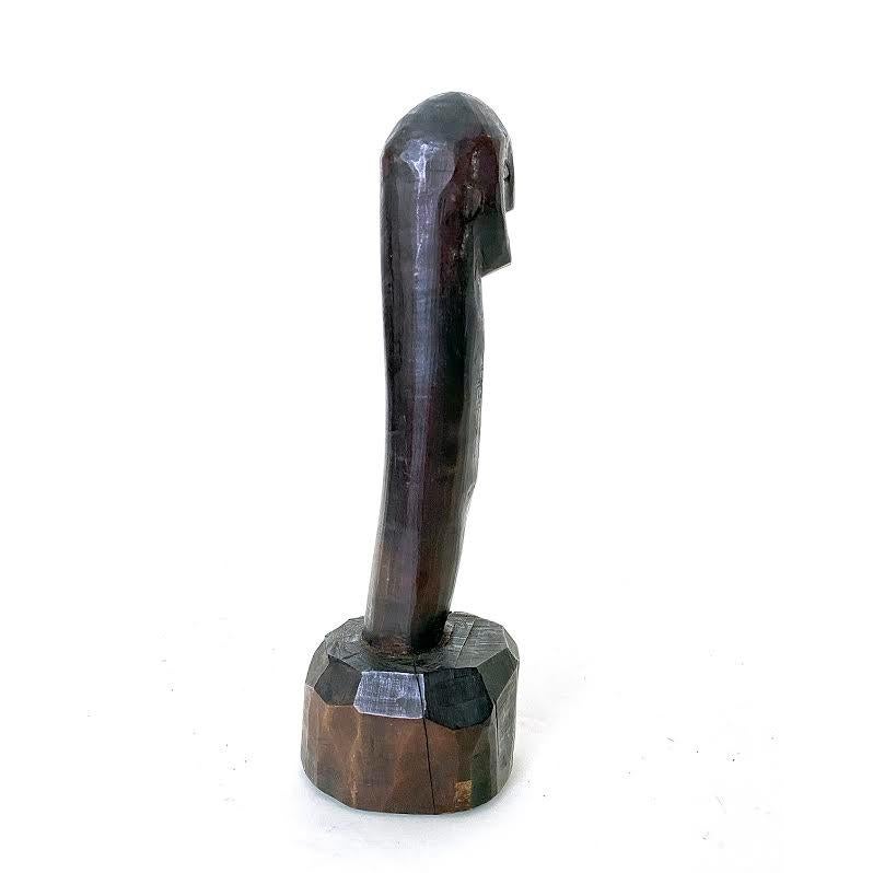 Wood condiment pounder, Northern Philippines, 20th century

A phallus-shaped pounder with a carved human face standing on a crude knifed cut surface. There is an old small line crack on the side of the head and another on the base.