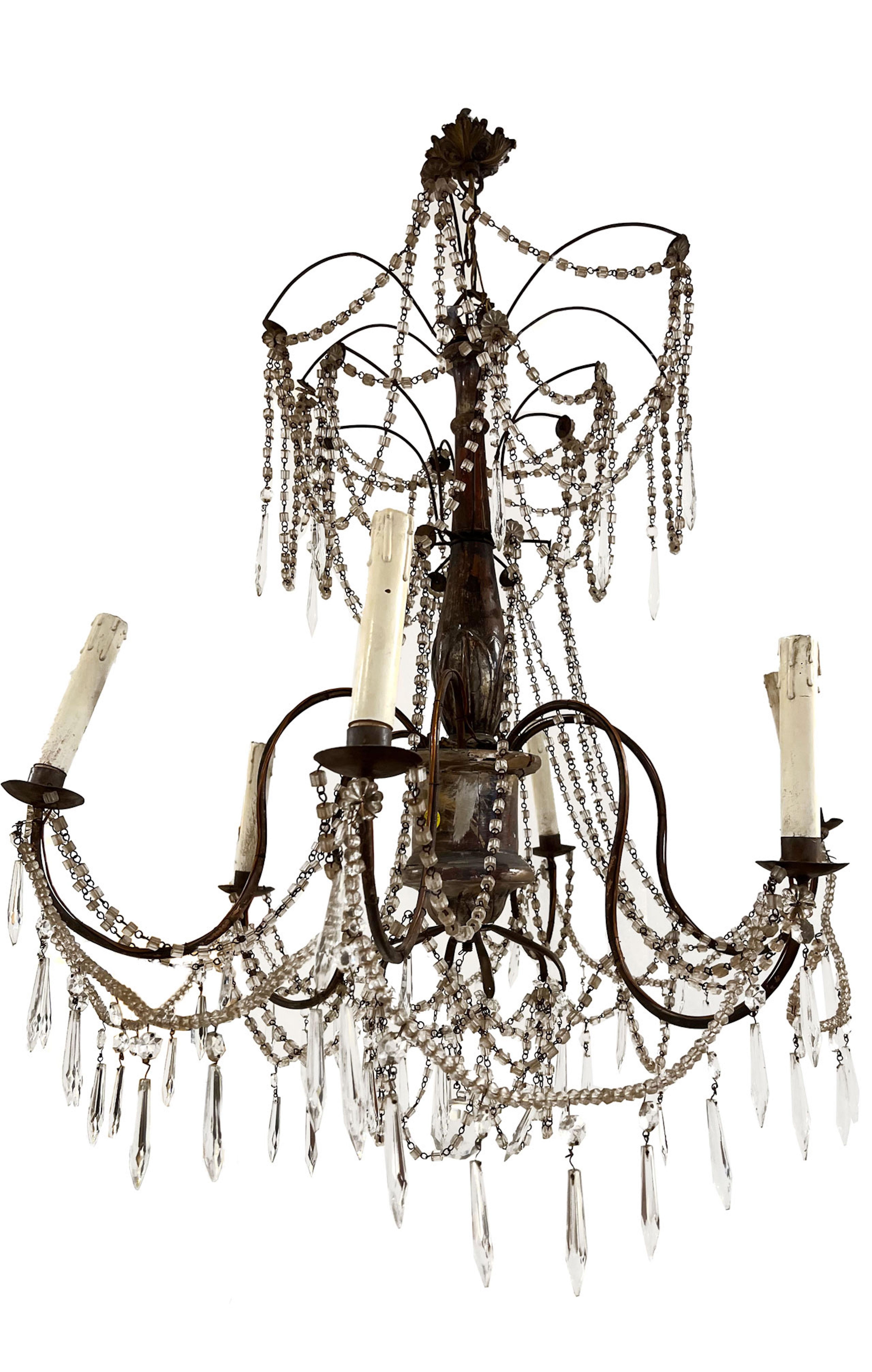 The aged patina of the silver leaf makes this pair of chandeliers a standout. Dripping crystal, elegance and sophistication are on display in the room that is fortunate enough to have them.