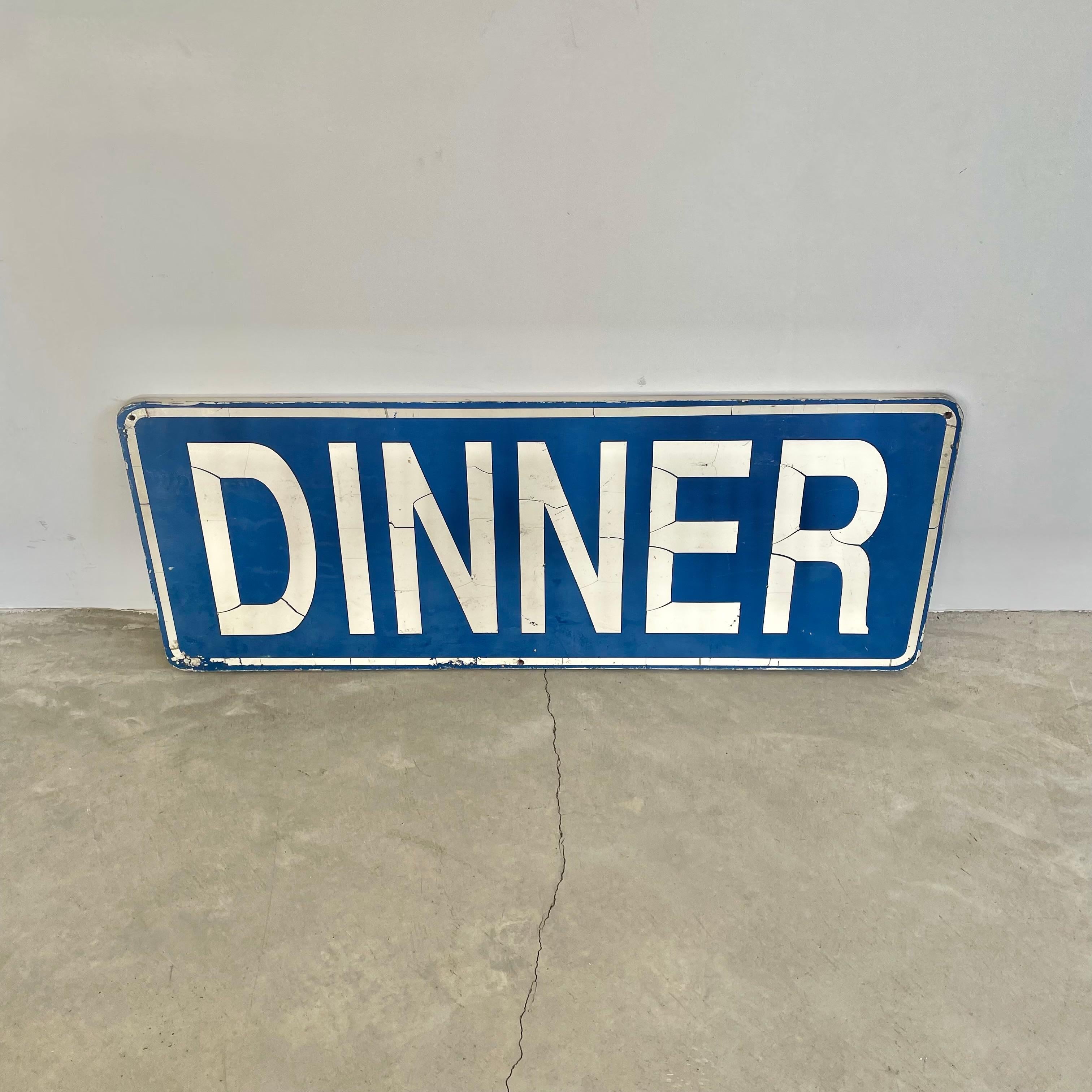 Prominent 1980s reversible DINNER sign in a unique and bold blue base color with white font and borders. The reverse side features colorful flowers and the word 