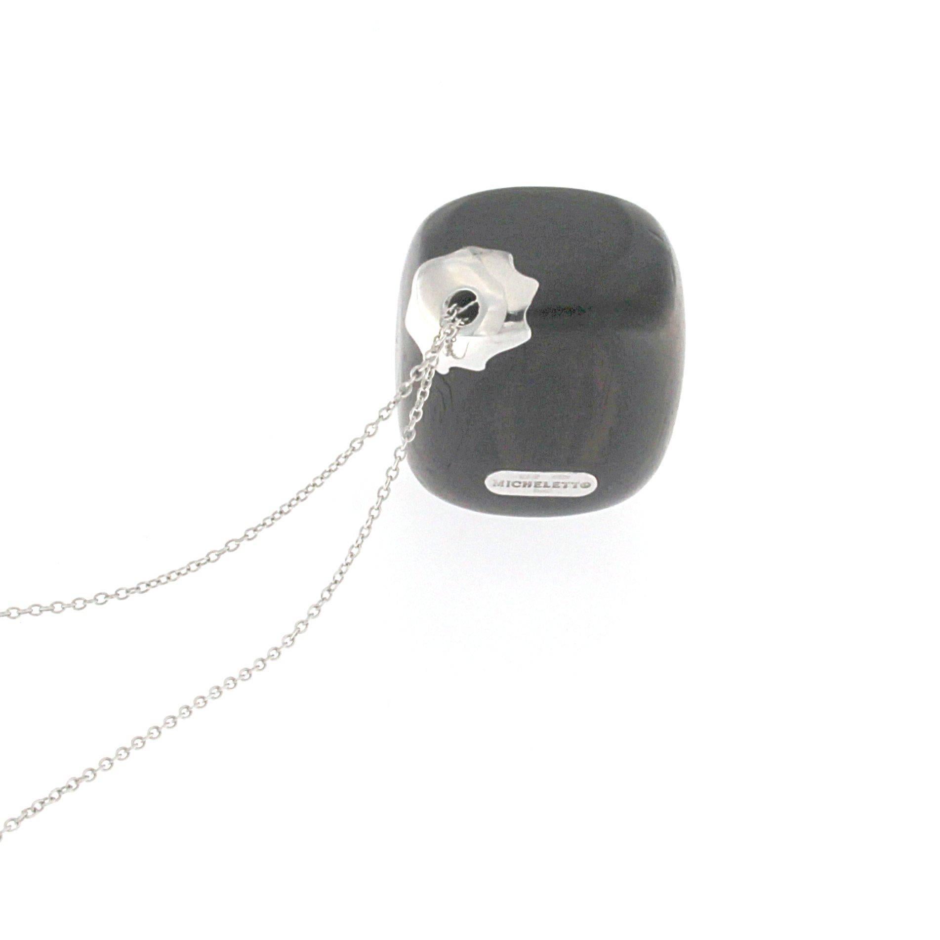 Questa raffinata collana combina la ricchezza del legno d'ebano, il più elegante e prezioso dei legni, con il lusso dell'oro bianco 18 carati. I toni profondi dell'ebano mettono in risalto la brillantezza dell'oro bianco, rendendolo una scelta