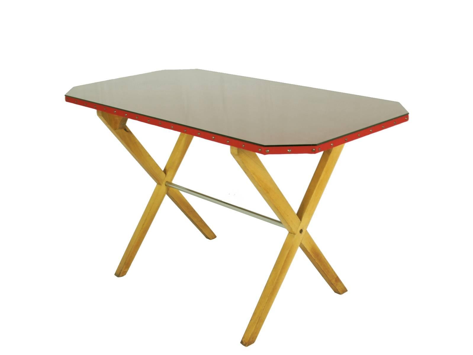 A beautiful and rare desk in the style of Franco Albini. It is made from a wooden crossed structure with a chrome-plated rod. A studded octagonal top is covered with red 