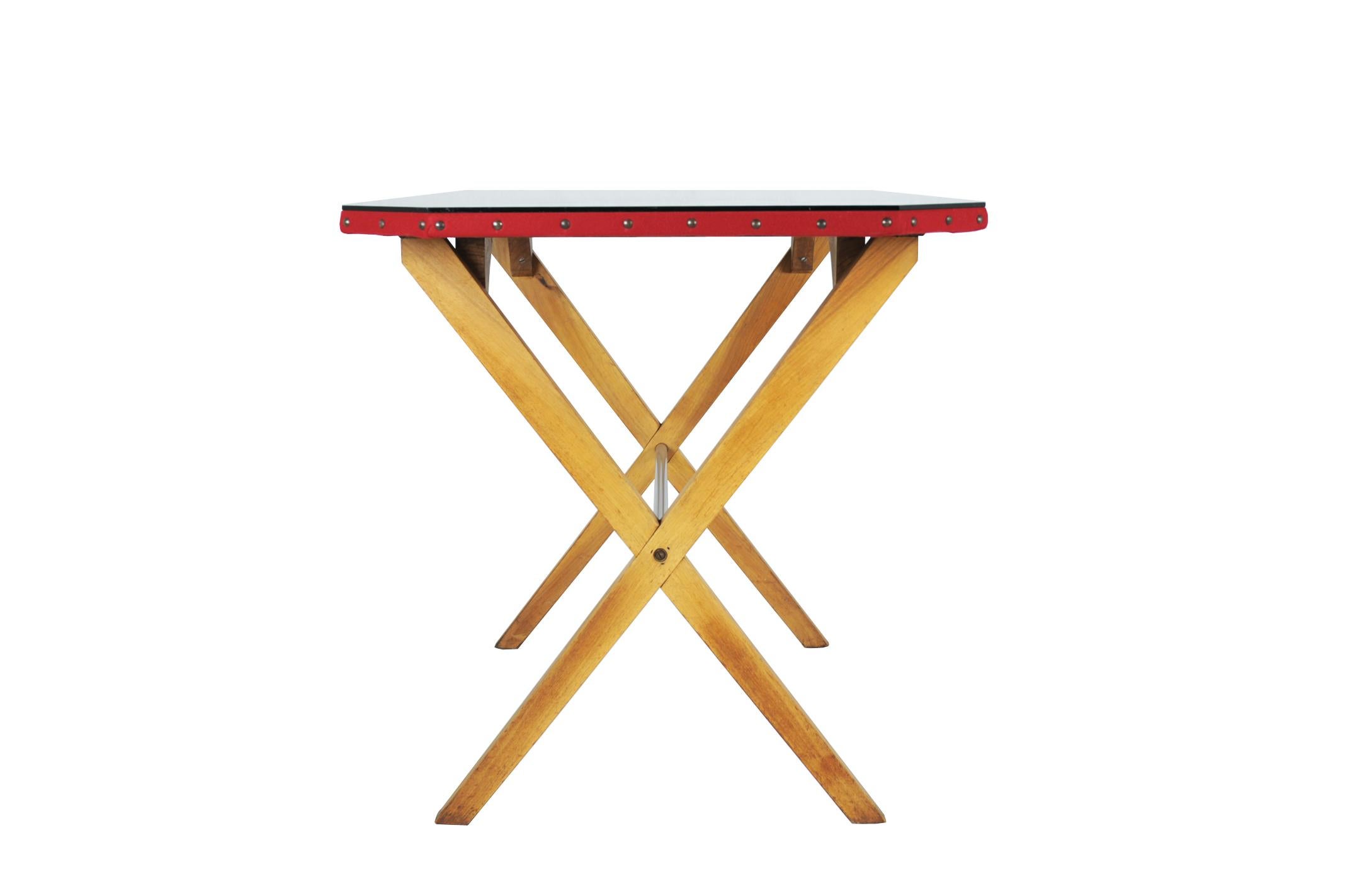 A beautiful and rare desk in the style of Franco Albini. It is made from a wooden crossed structure with a chrome-plated rod. A studded octagonal top is covered with red 