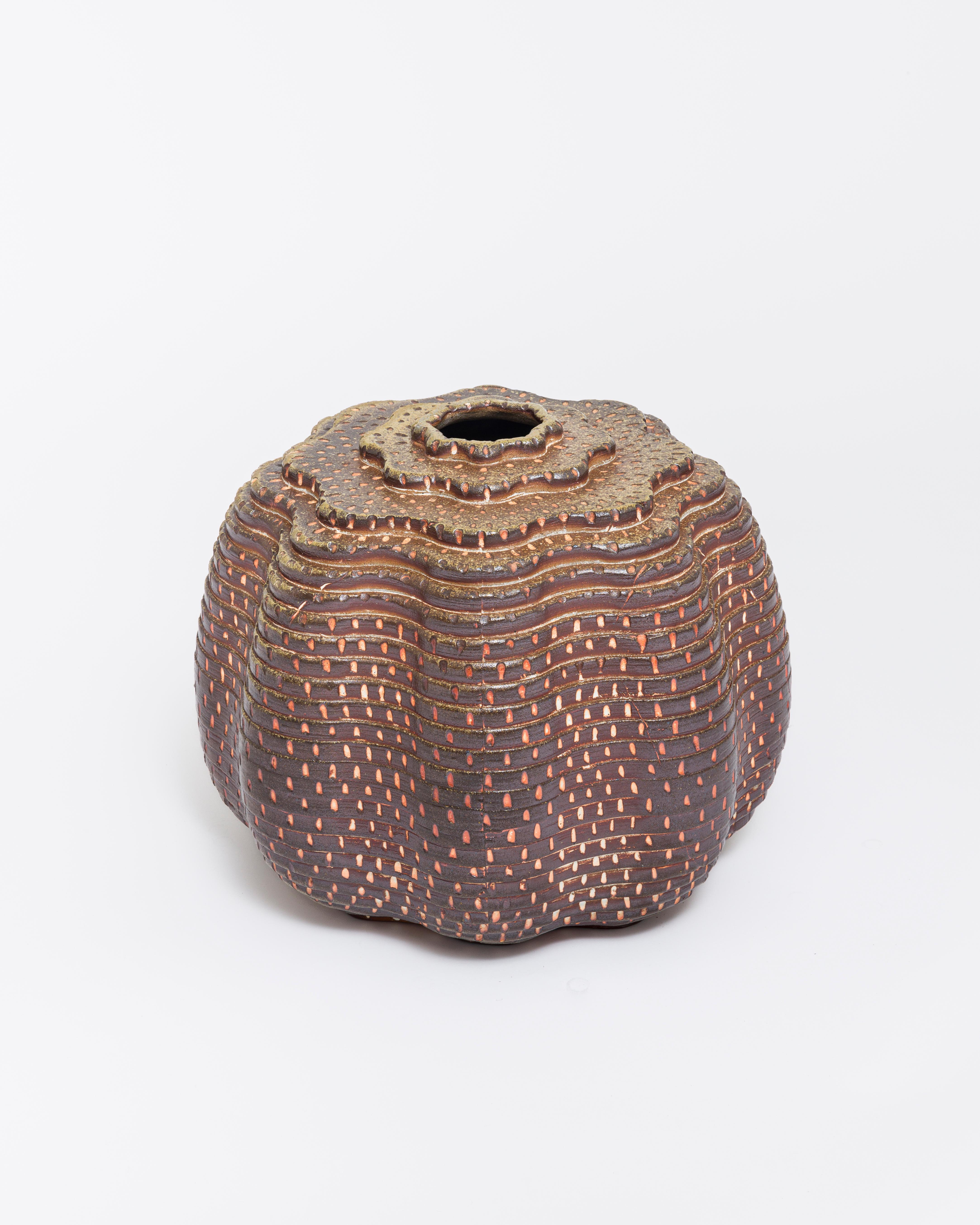 A large-scale decorative and functional (it can hold water) vase. The color comes from  the natural wood-fired process. The surface has been etched before firing, creating a uniform pattern across the graduating tiered surface. An extremely