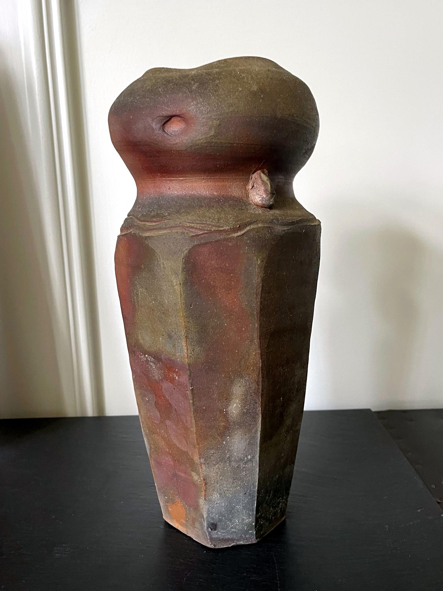 Un vase en grès de Paul Chaleff (1947-) réalisé en 1984. Chaleff est connu pour ses récipients en céramique cuits au bois, sans glaçure ou parfois avec une glaçure cendrée naturelle. Le vase proposé est d'une forme très géométrique avec un corps