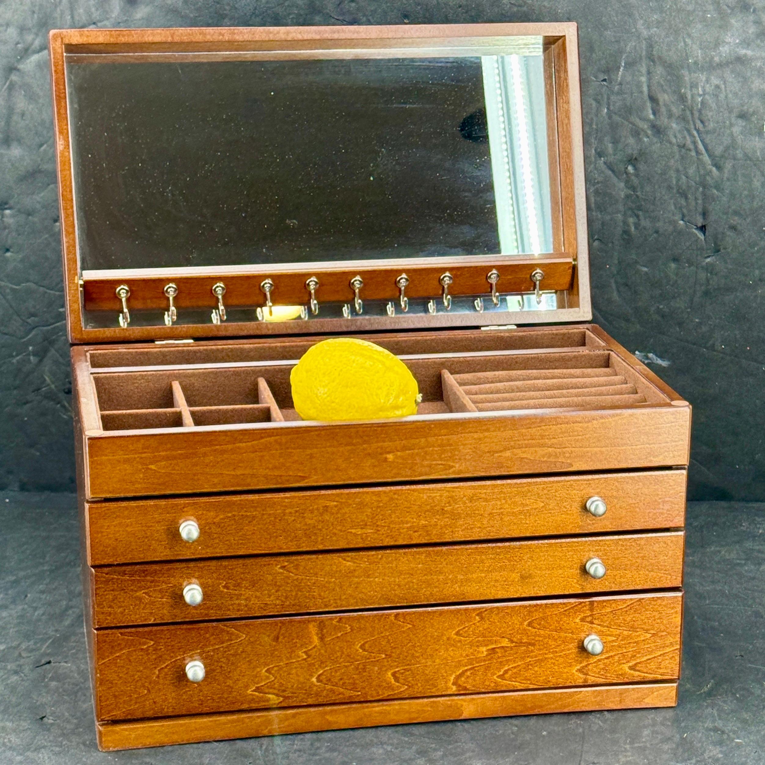 Grand coffret à bijoux en bois : Couvercle rabattable avec miroir intérieur, dix crochets pour les colliers,
compartiment supérieur avec cinq sections plus des rouleaux d'anneaux, trois tiroirs, le tiroir supérieur a dix sections, le tiroir du