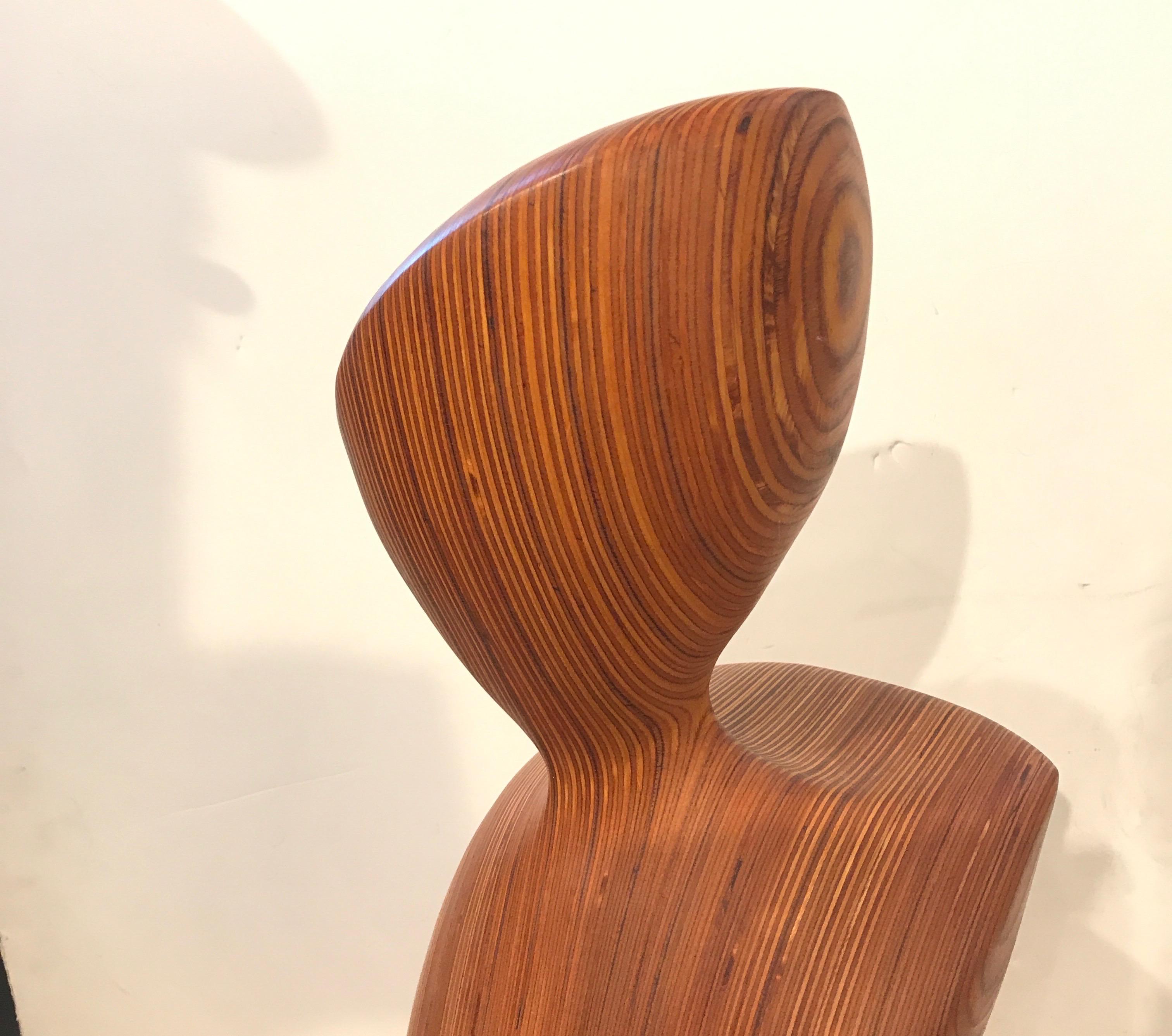 A midcentury abstract sculpture of a woman made from laminated layers of wood. Shapely figure with the head, torso and hips with the interesting layers of laminated solid wood, USA, circa 1960.
