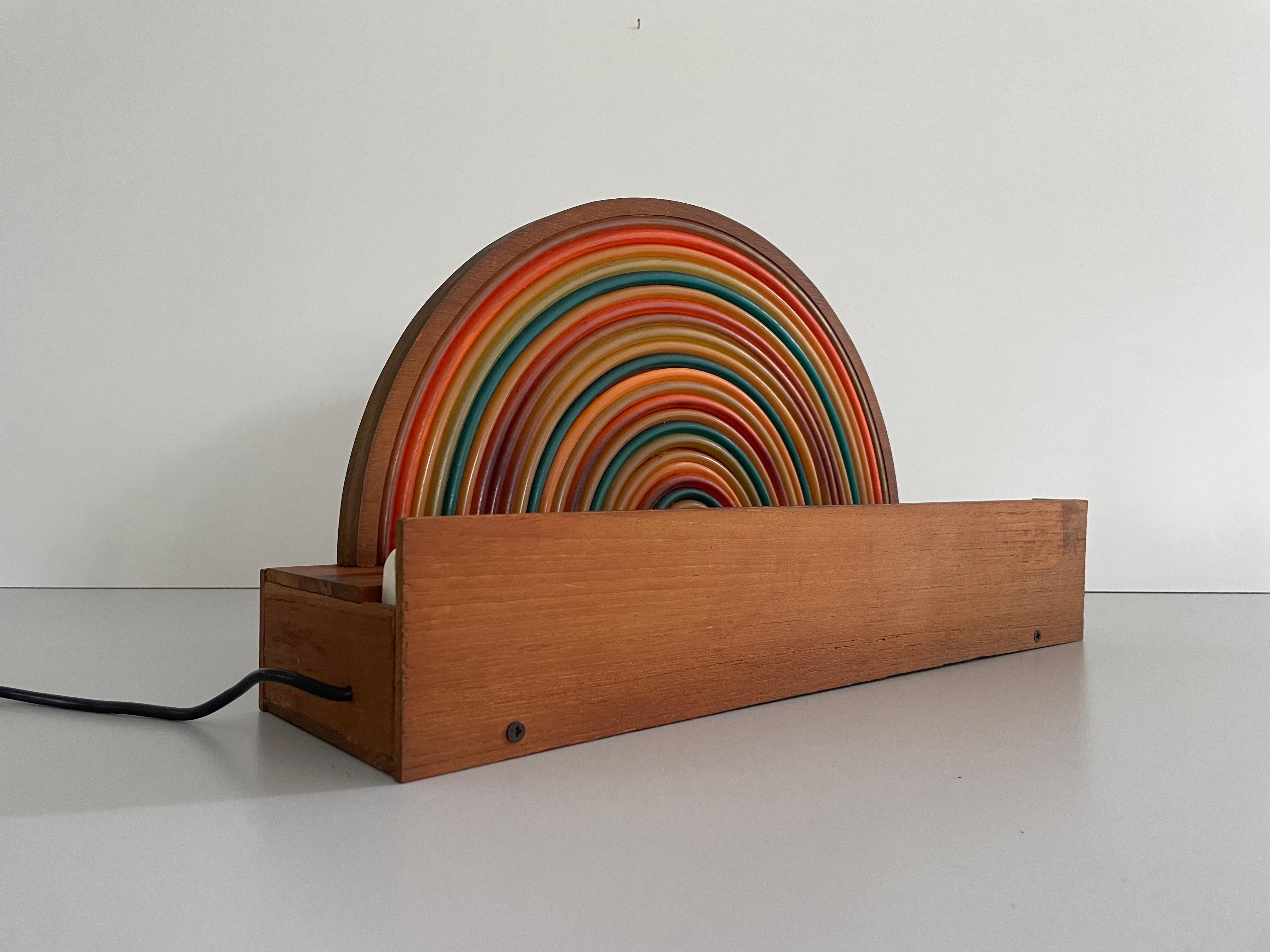 Wood Rainbow Bedside Night Lamp with Fluorescent Light, 1960s, Italy

Lamp is in very good vintage condition.

Note : On the front of the lamp there are colored plastic bendable parts.

This lamp works with Fluorescent Light. 
Wired and suitable to
