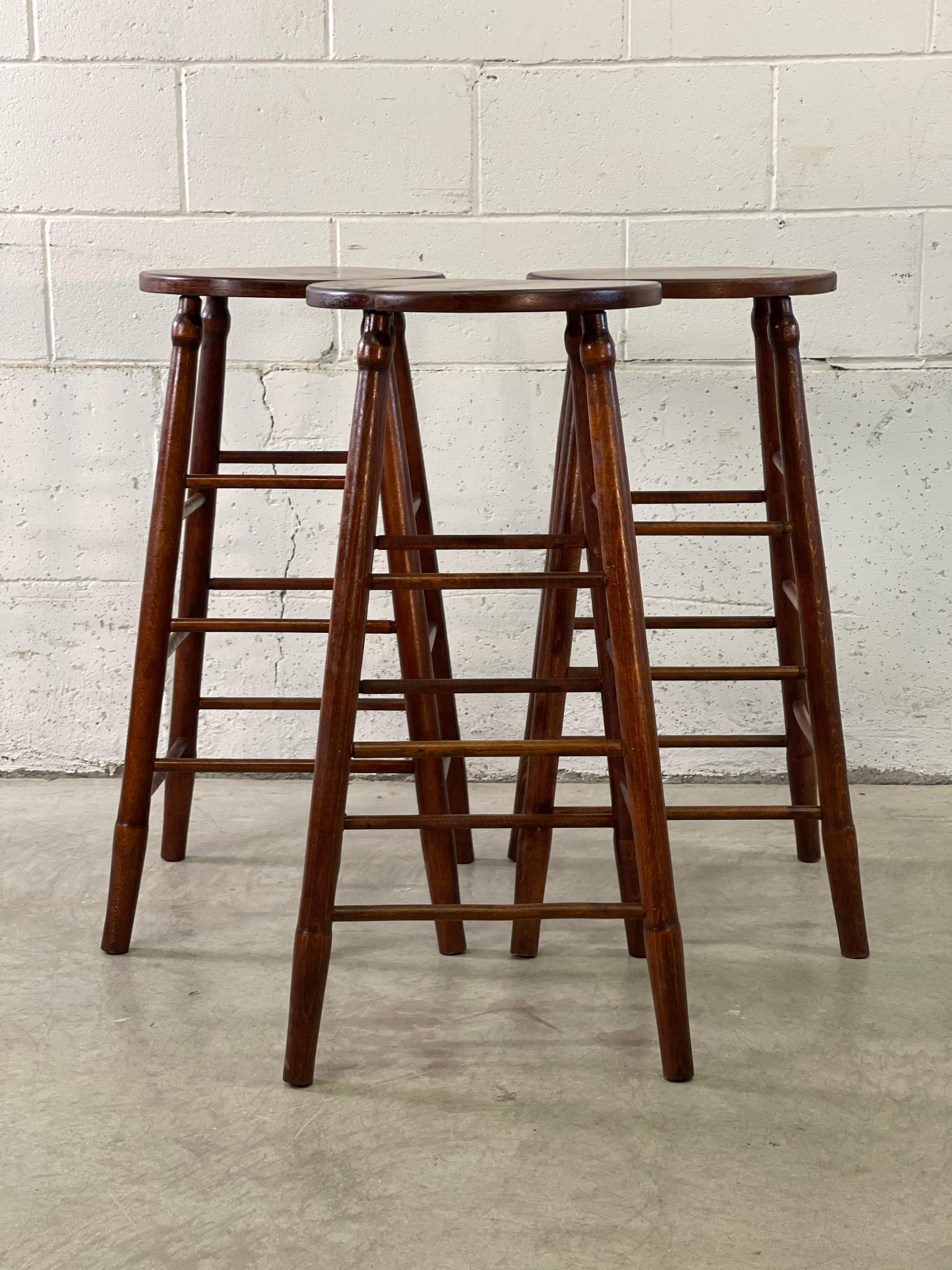 Vintage-Set aus 3 Barhockern aus Holz mit runden Sitzen. Neu lackiert und in stabilem Zustand. Keine Markierungen.