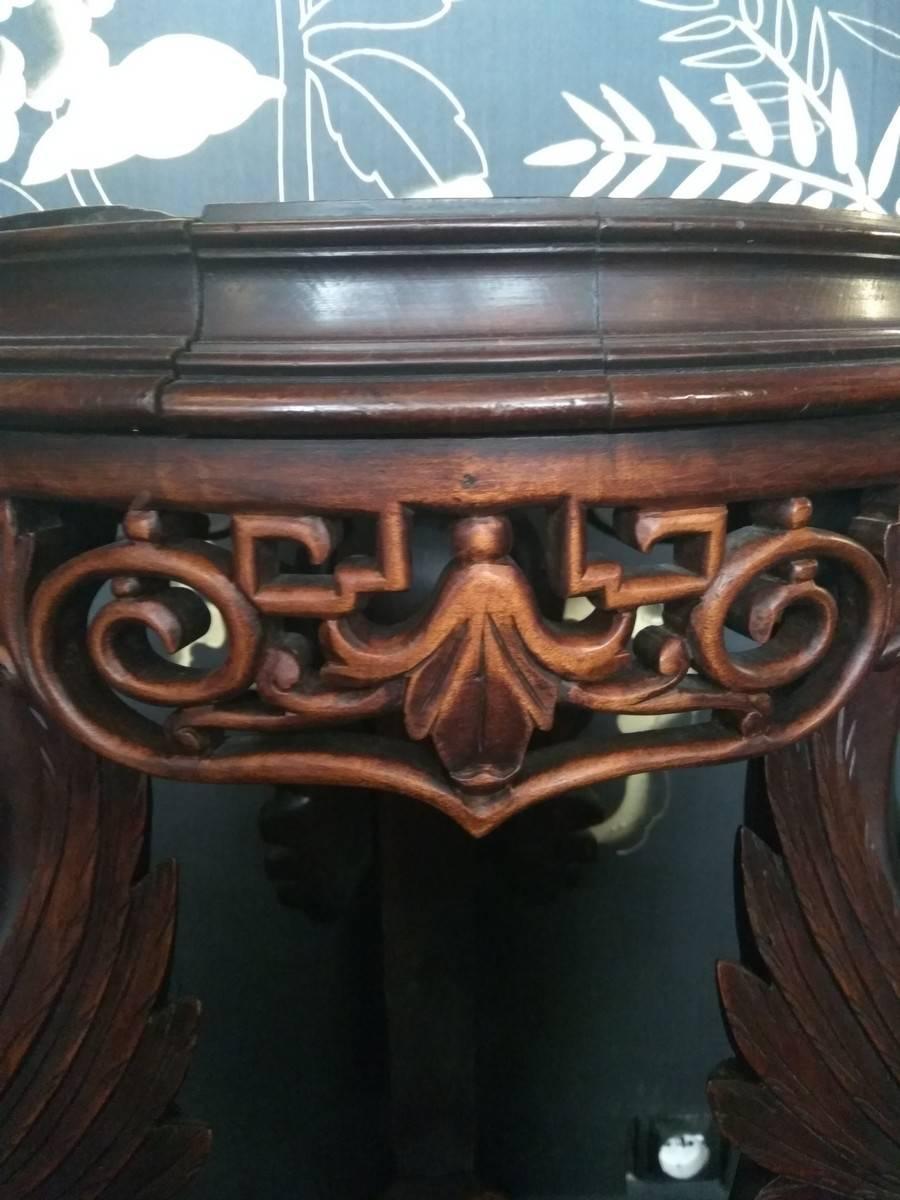 Beautiful wood stand with a top encircled with Chinese inspired carved openwork motifs. The stand is composed of chimeras heads and three curved legs ending with claw feet and enclosing an openwork crotch shelf. This wood stand illustrates perfectly