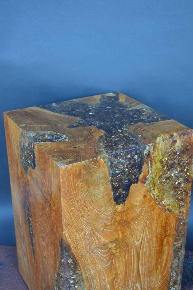 Wood stool encased in resin with amber color.