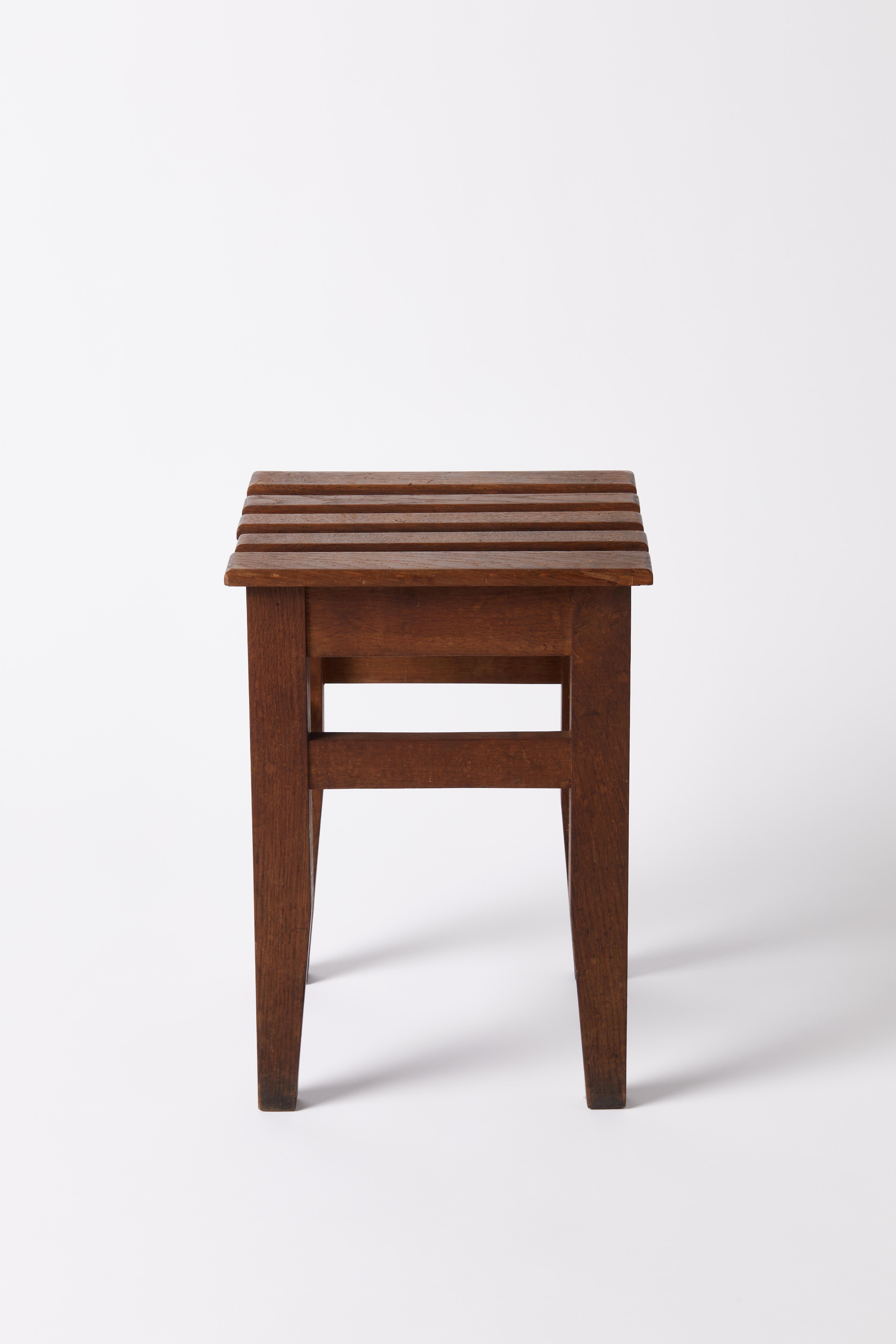 Kleiner Holzhocker mit spitz zulaufenden Beinen.