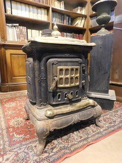 Wood stove, branded Parlor Stove, in black cast iron, gold-plated brass finishes