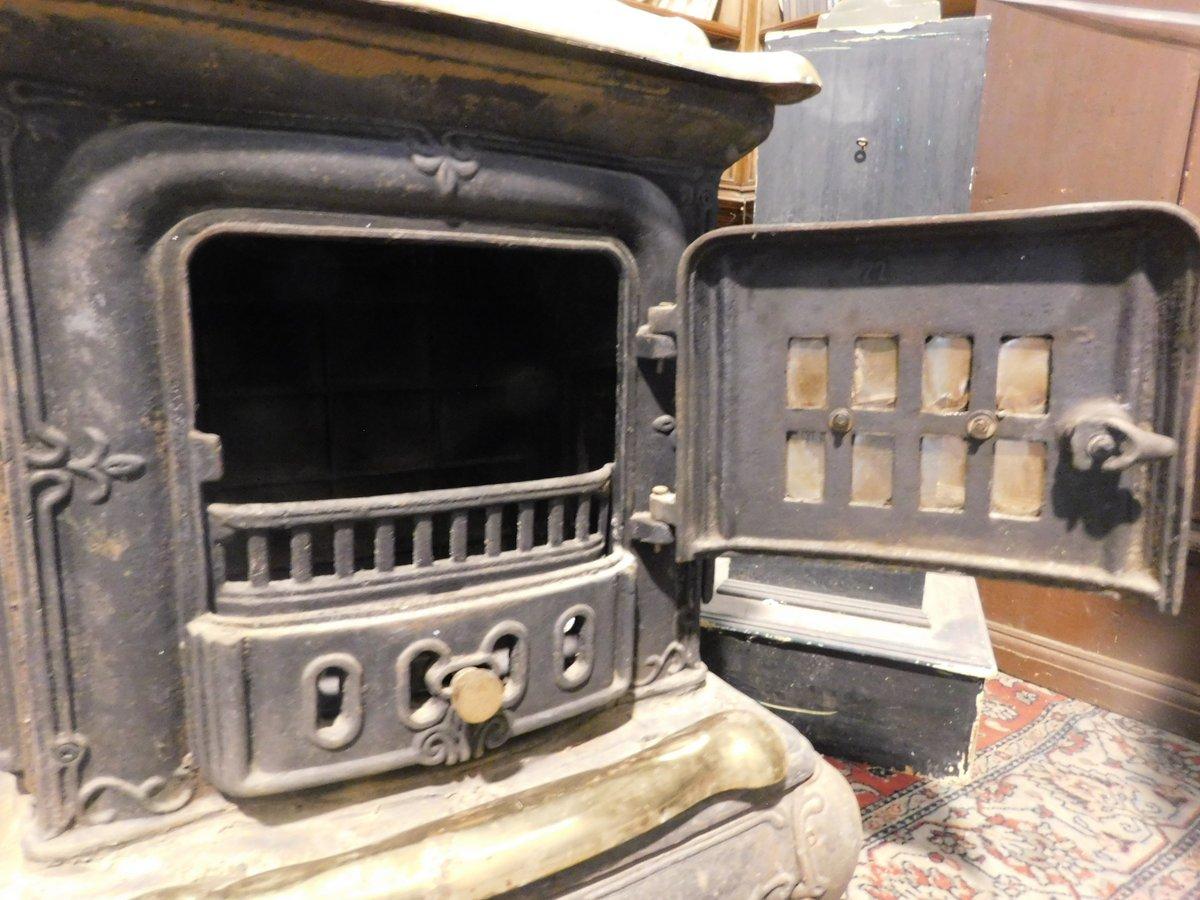 Estufa de leña, marca Parlor Stove, en hierro fundido negro, acabados en latón dorado Hierro