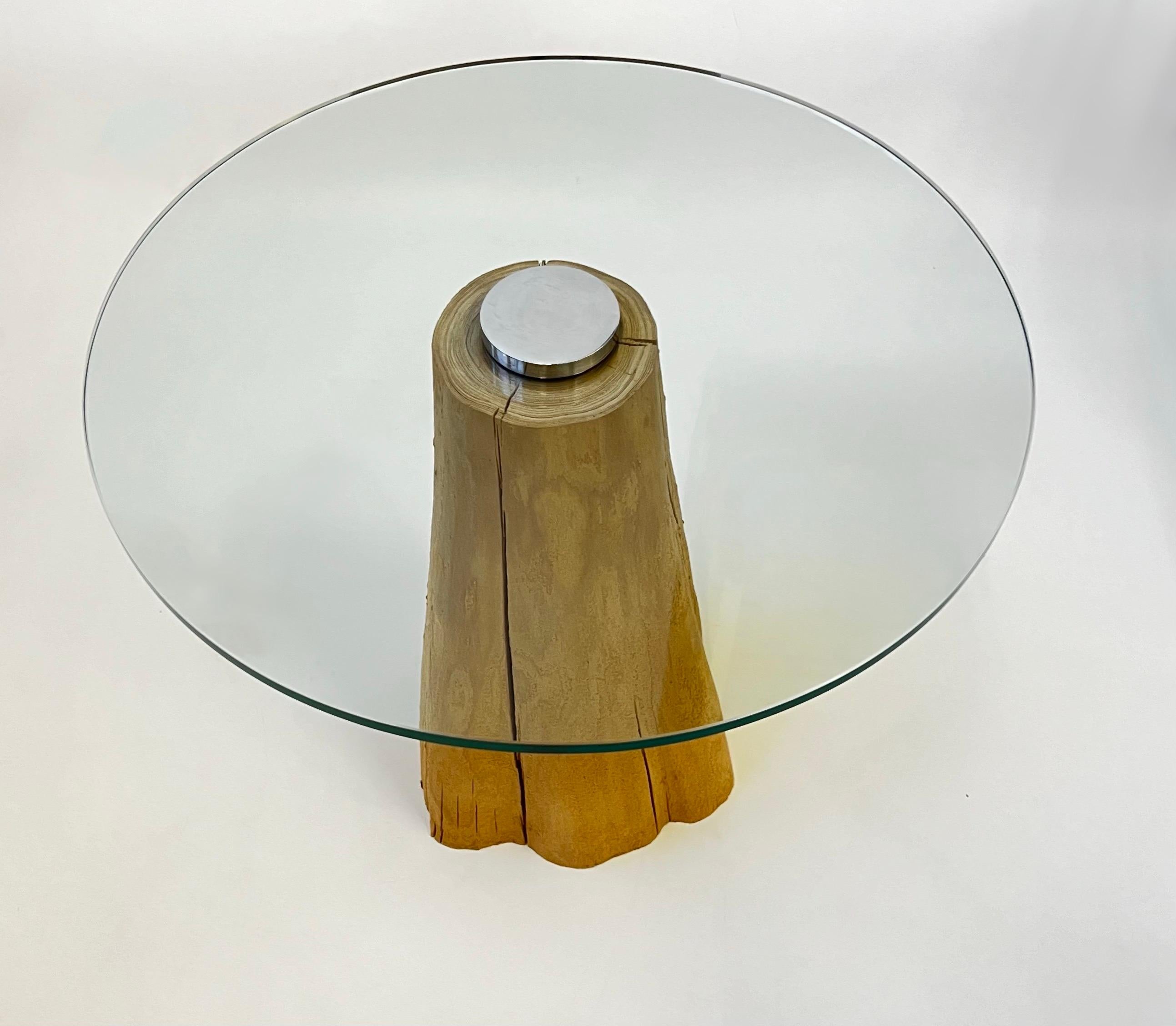 A beautiful 1970s wood stump with a round glass top side table by Michael Taylor. New 1/2” thick glass top. The hardware that holds the glass top to the stump is polish aluminum. 

Dimension: 20” diameter, 16.25” high.