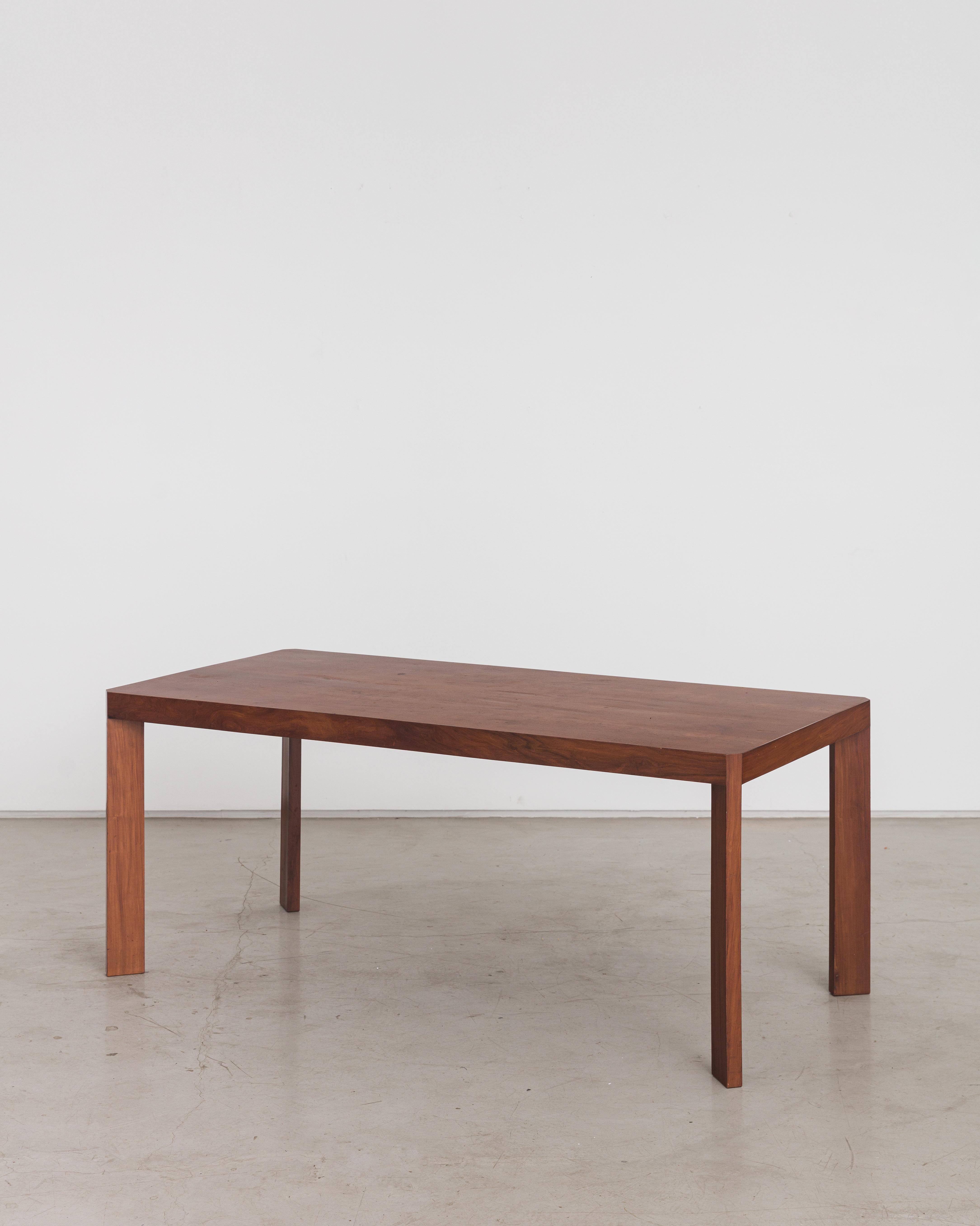 This stunning Caviúna piece was designed by Joaquim Tenreiro and produced in 1968 by one of his companies, located in Rio de Janeiro. Its simple design stands out with the subtle detail of the rectangular-shaped feet, positioned diagonally and