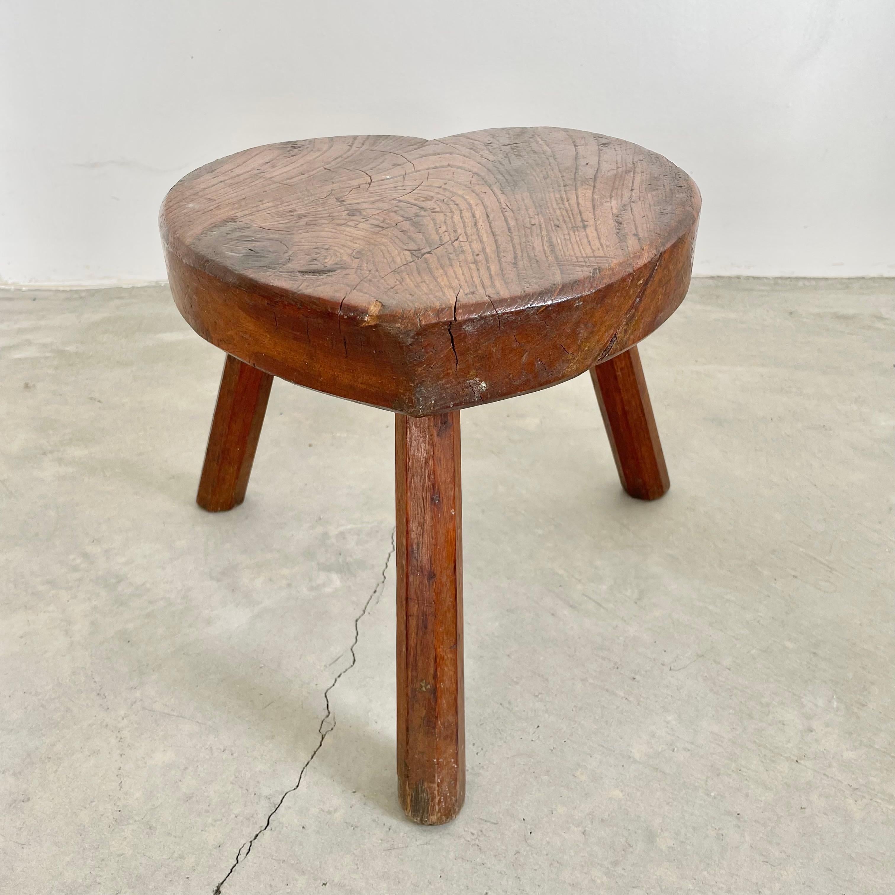 Unique heart tripod stool made in France, circa 1950s. Substantial and chunky heart shaped seat with three sturdy club legs with faceted sides. Perfect patina and age to this piece. Functional stool. Perfect for books or objects as well. Seat