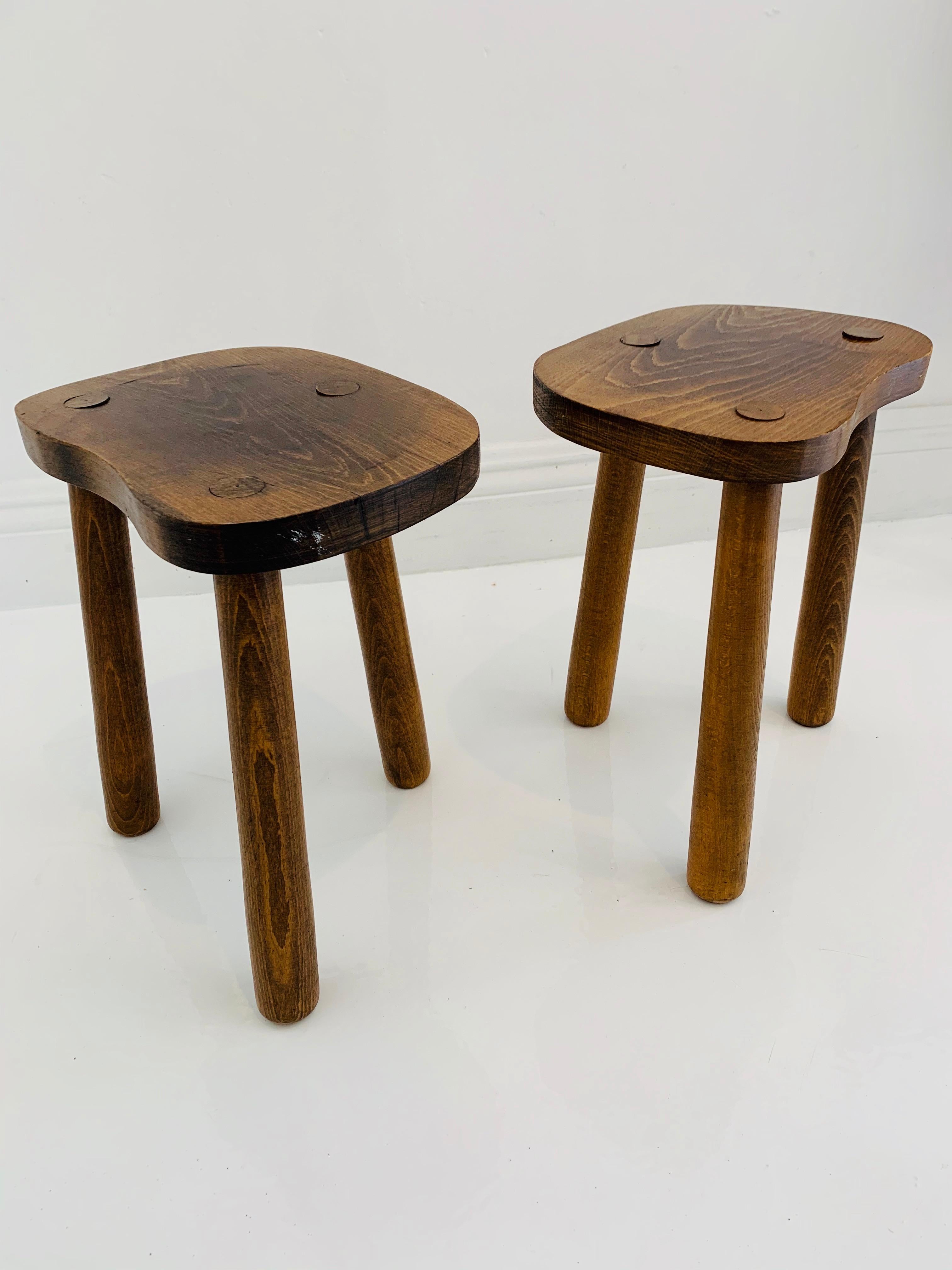Vintage wooden milking stools made in France, circa 1950s. Thick seat with tripod legs. No nails or hardware. Great lines and shape. Petite stool with great presence. Great vintage condition. Two available. Priced individually.
 