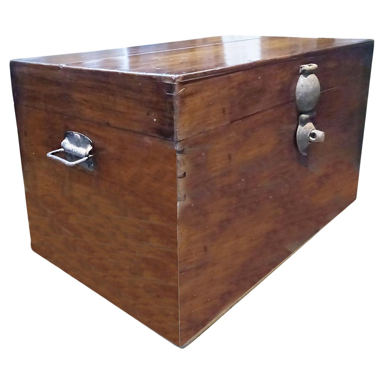 An early 20th Century wood trunk, hand-crafted in Borneo, Indonesia. 

The outside of the trunk is finished in caramel brown, with original metal handles on the sides and also its original metal lock. The inside is unfinished cedar, with one small