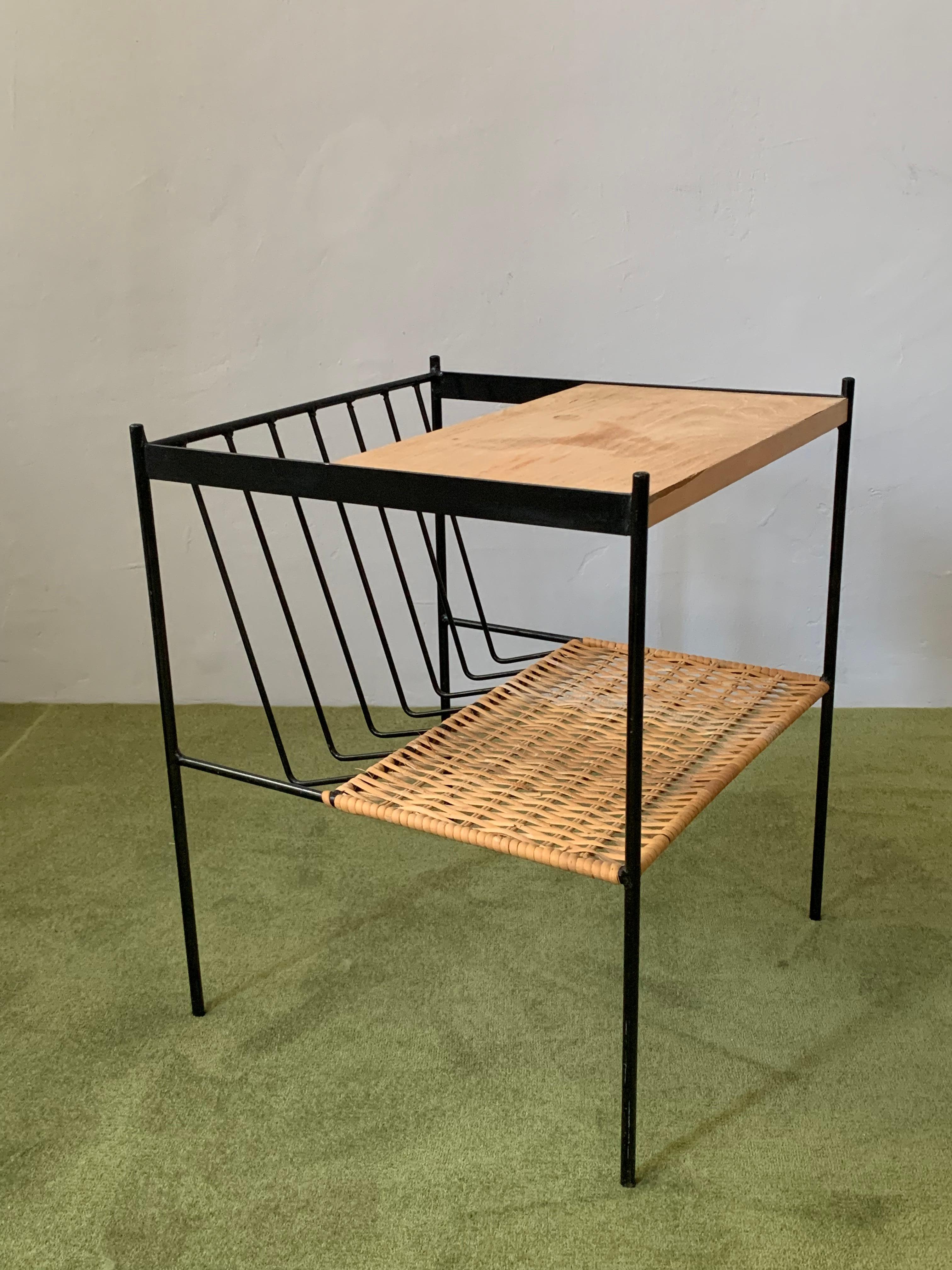Beautifully formed magazine table with upper slab made of wood and a lower one made of wicker is now available. The magazin storage part is black colored iron such as the structure of the table itself. 
Restored in very good condition. Apart from