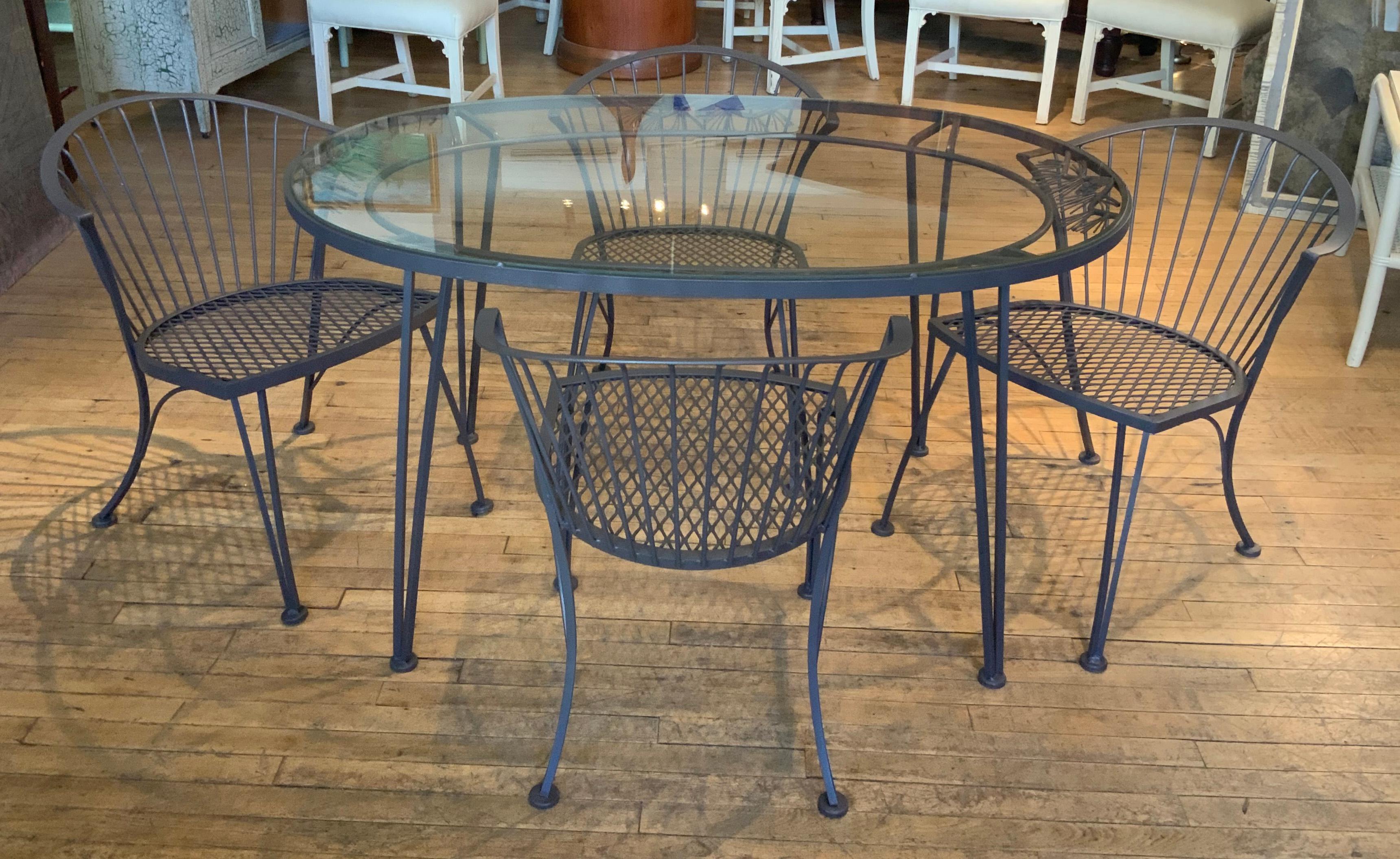 A vintage 1950s wrought iron garden dining set by Woodard. 'Pinecrest' was one of their most charming designs in the 1950s, named for the pine needle & pinecone motif in the skirt of the dining table. this set consists of a beautiful oval dining
