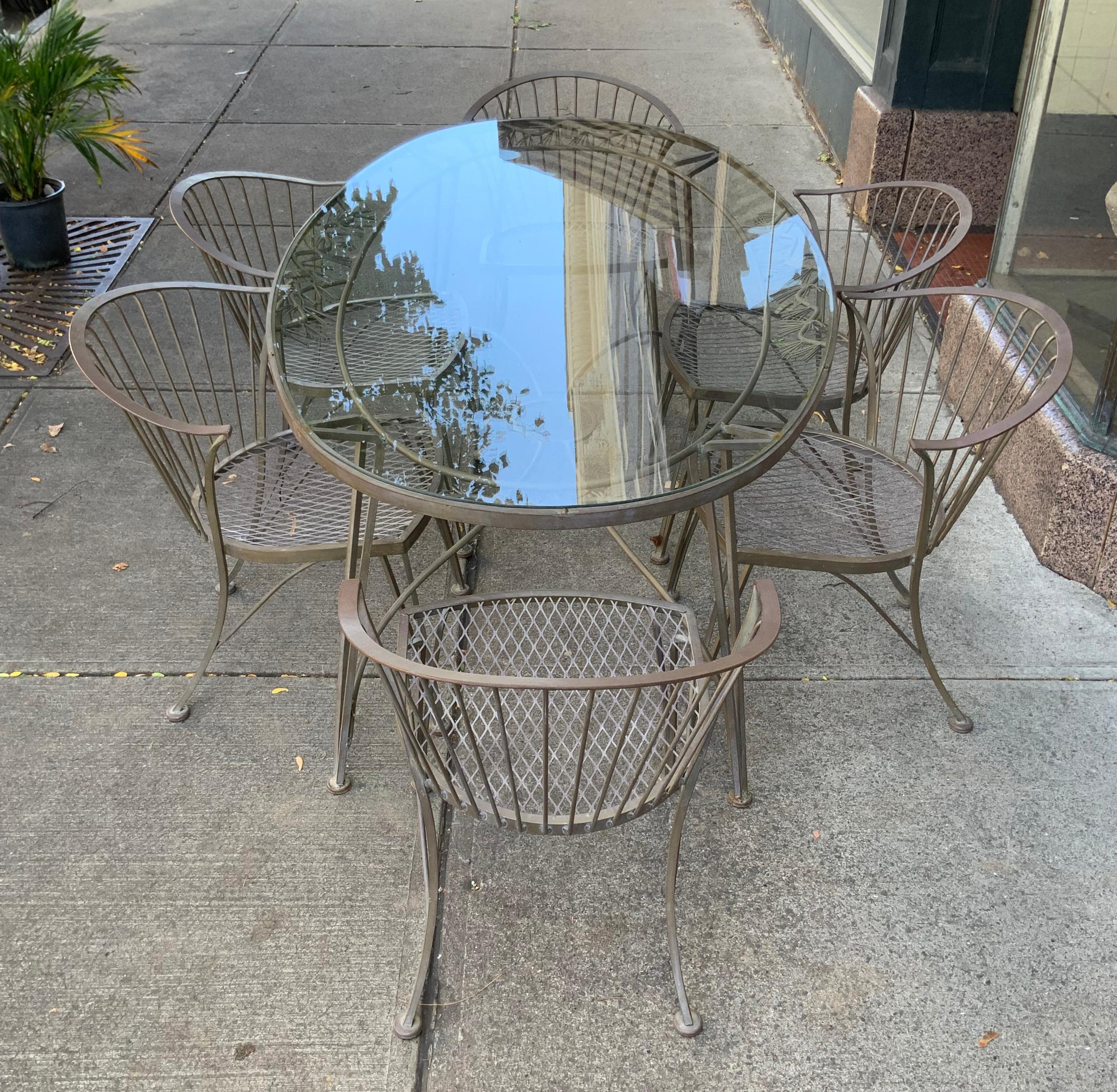 A vintage 1950s wrought iron garden dining set by Woodard. 'Pinecrest' was one of their most charming designs in the 1950s, named for the pine needle motif in the skirt of the dining table. this set consists of the large oval dining table, with the