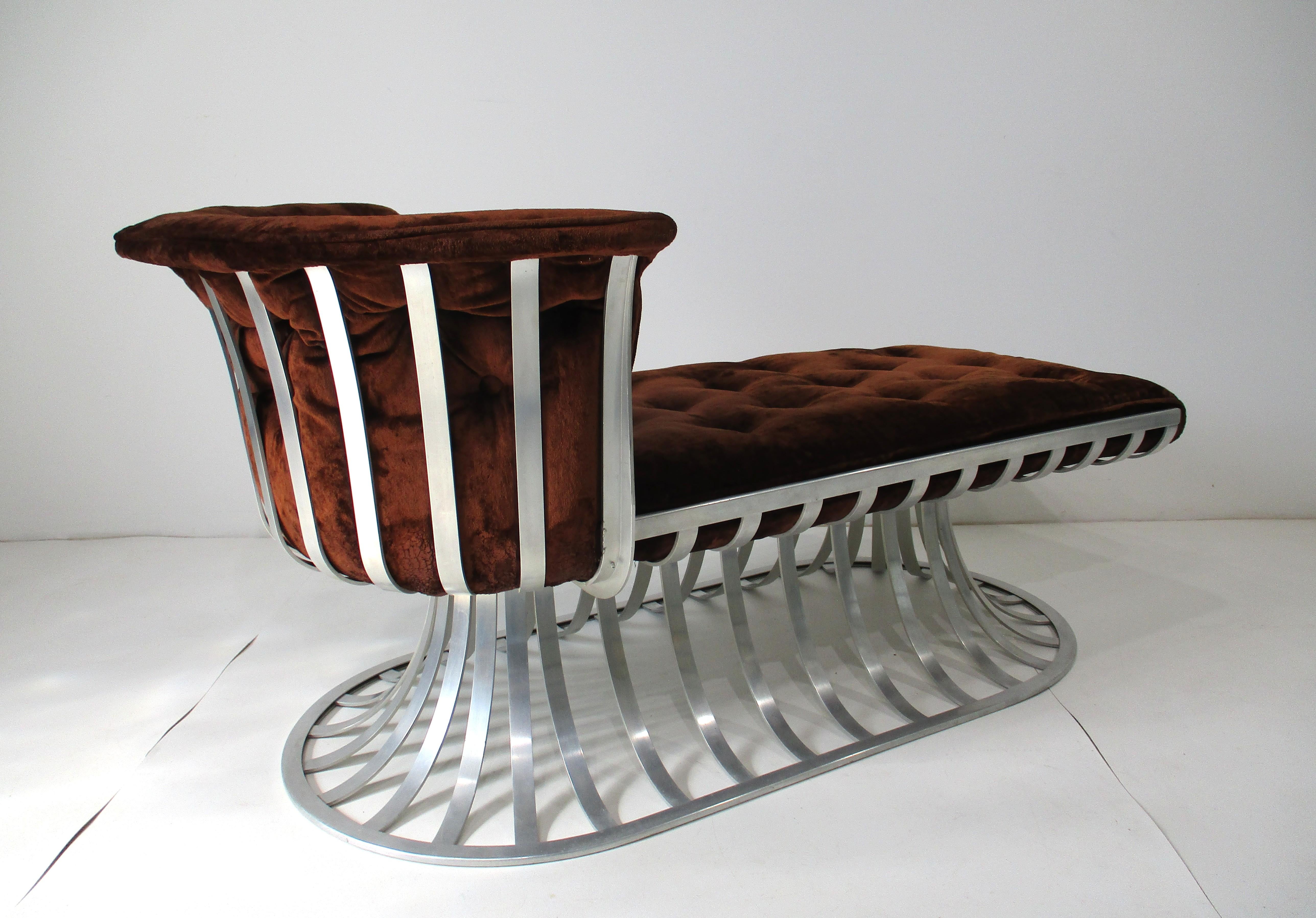 A luxurious and very well-crafted chaise lounge chair with a sturdy sculptural aluminum banded frame. This stunning piece is upholstered in a chocolate-colored crushed velvet with button bottom and back cushions with the back one formed to surround