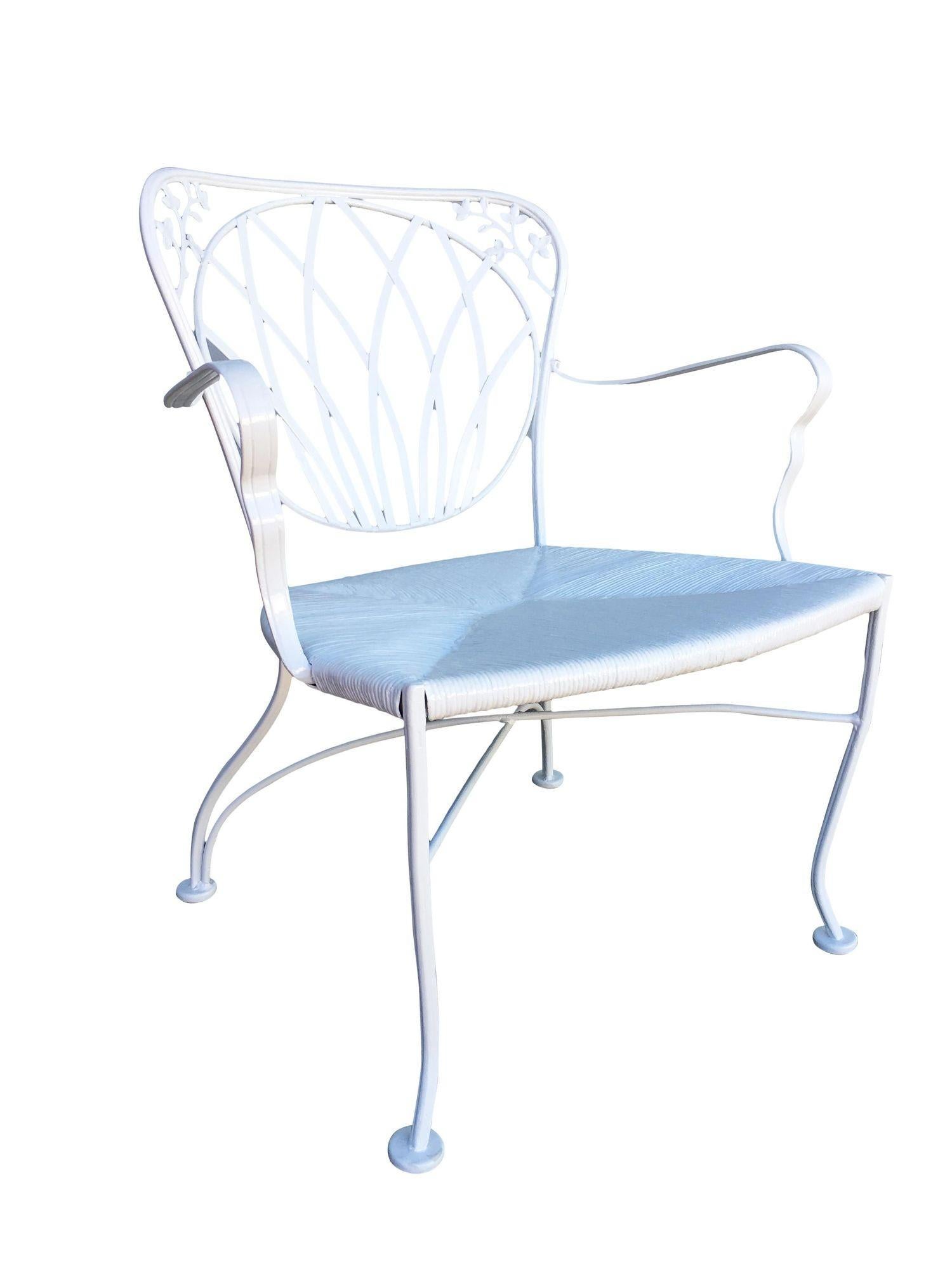 Set of 4 Woodard rod iron outdoor/patio chair with a distinct Art Nouveau backrest. This chair is constructed with solid core iron castings and is finished in your choice of a pure white or black finish with padded seats, circa 1950. All outdoor