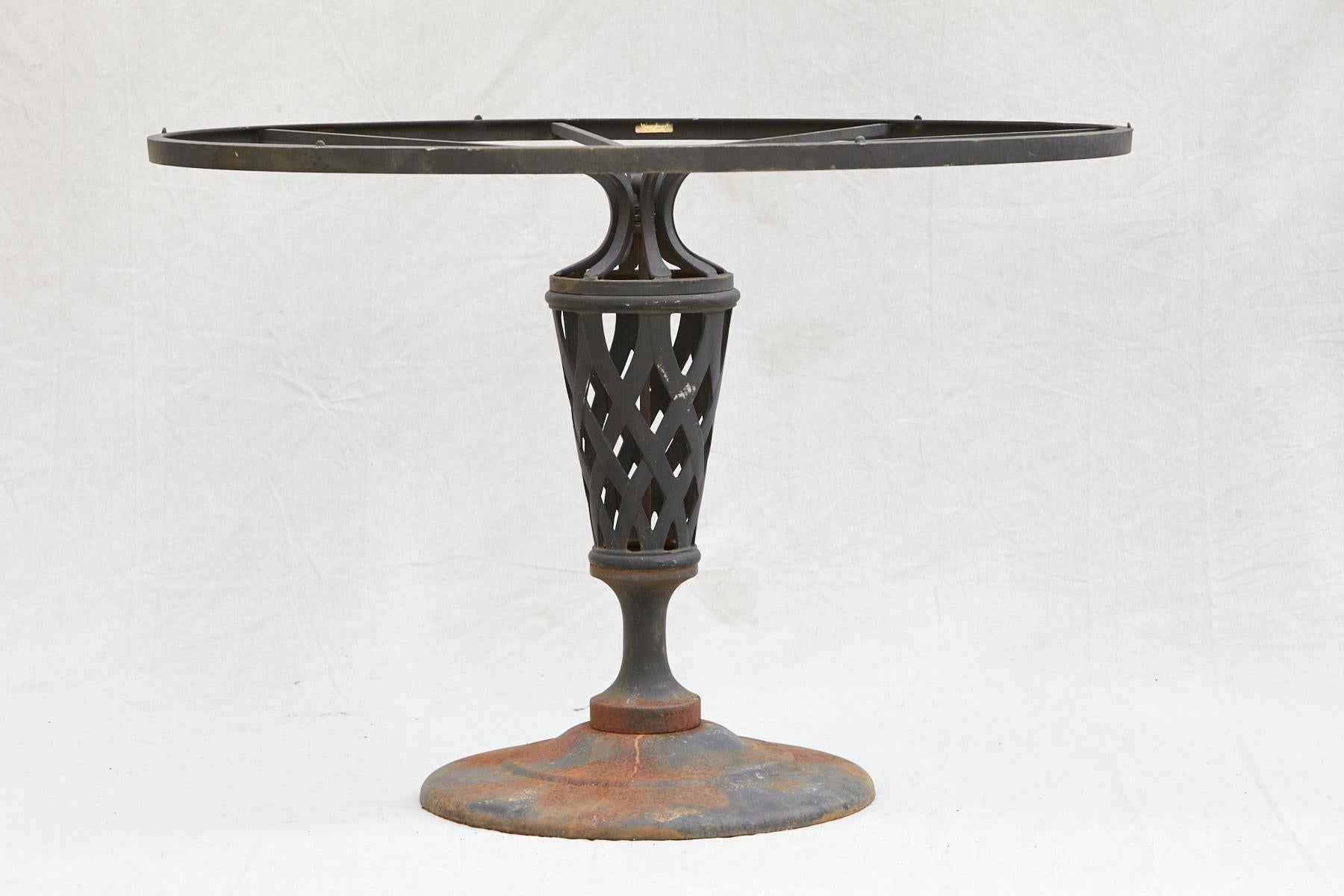 Woodard black iron garden/center table on a pedestal with a lattice pattern, 1980s
The table has some paint loss and rust, which gives it a charming patina.
Woodard sticker inside of the table frame visible.
  