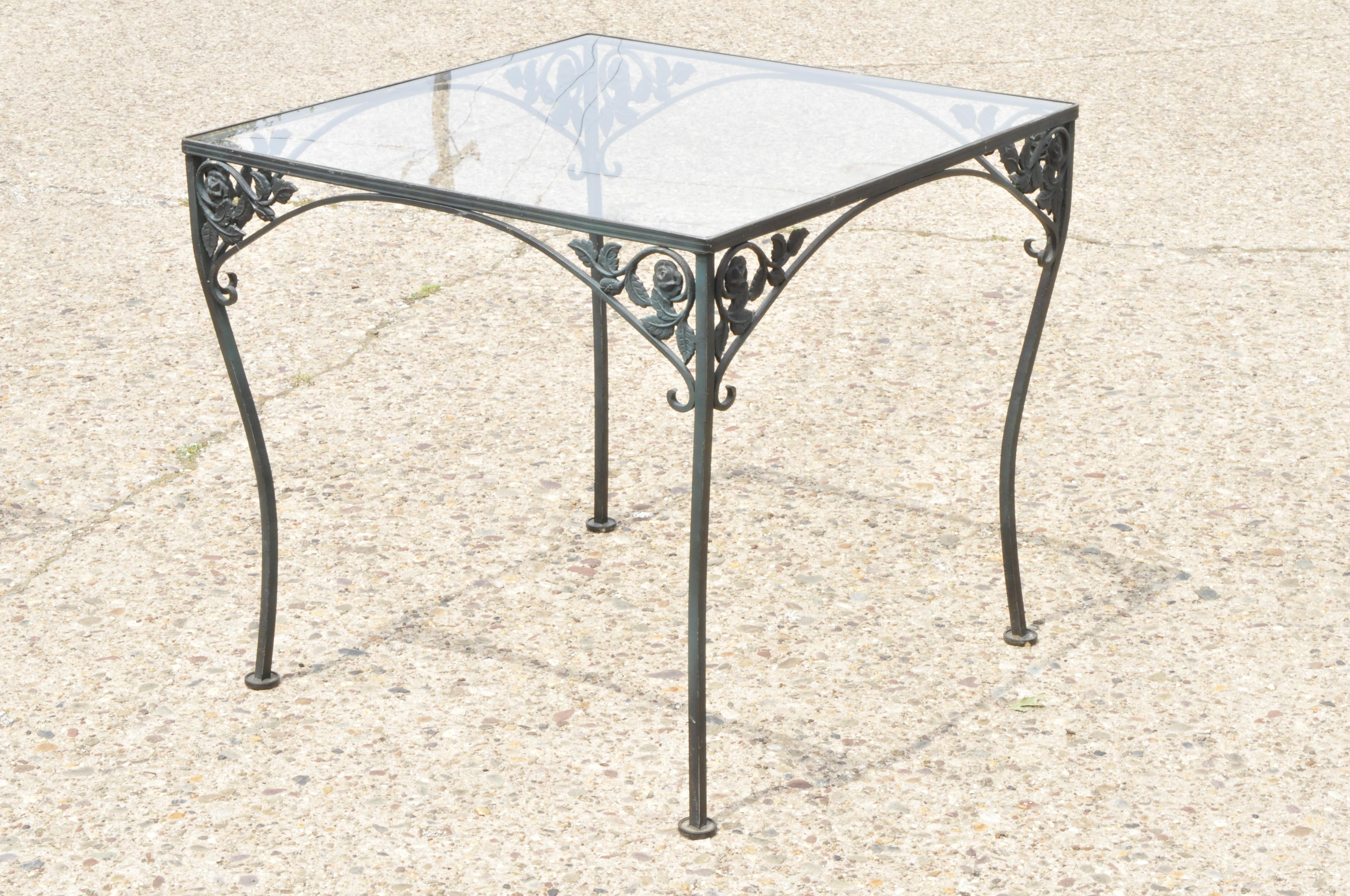 Ensemble de 4 chaises et table carrée pour terrasse de jardin Woodard Chantilly Rose. L'annonce présente un ensemble de 5 pièces, une table carrée à plateau en verre, 4 chaises latérales, motif Chantilly Rose, très bel article ancien, fabrication