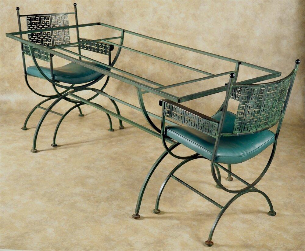 Mid-Century Modern dining table and four armchairs, by Woodard in iron, handmade in America, circa 1960. Original verdigris patina and dark green leatherette upholstery.

Measures: Table 66 long x 30 deep x 30 high.

Chairs 21 wide x 19 deep x