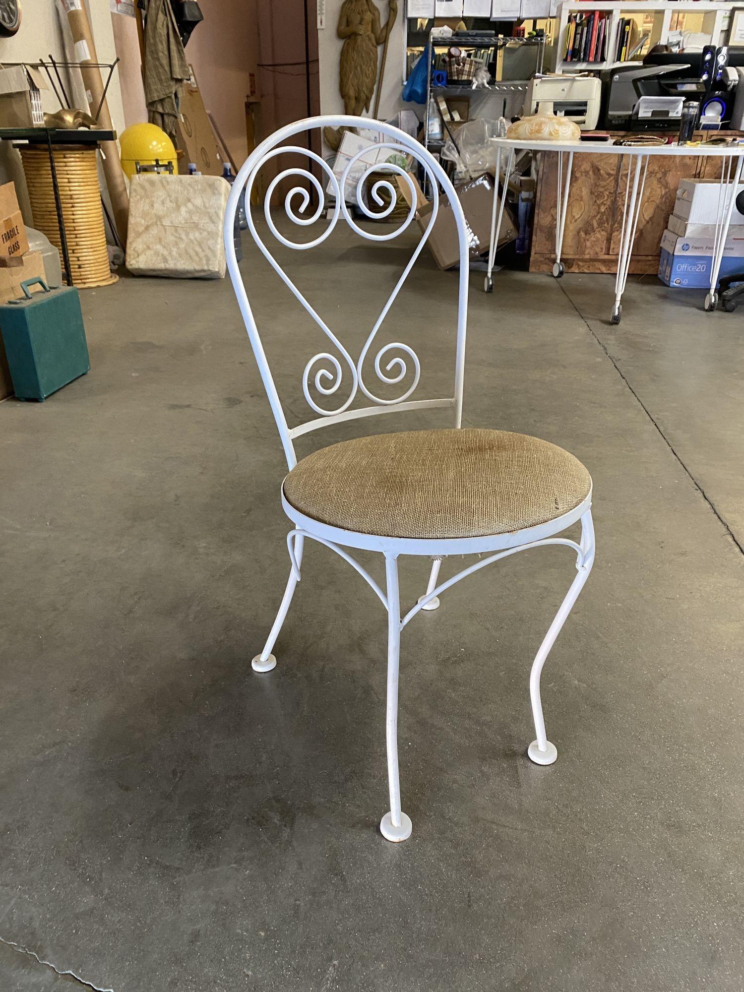 Mid-century Iron Bistro outdoor/patio set includes both tables with chairs, a distinct scrolling backrest, and table decor. This set was constructed with solid-core iron castings and is finished in white. Similar to the patio sets found in Italy and