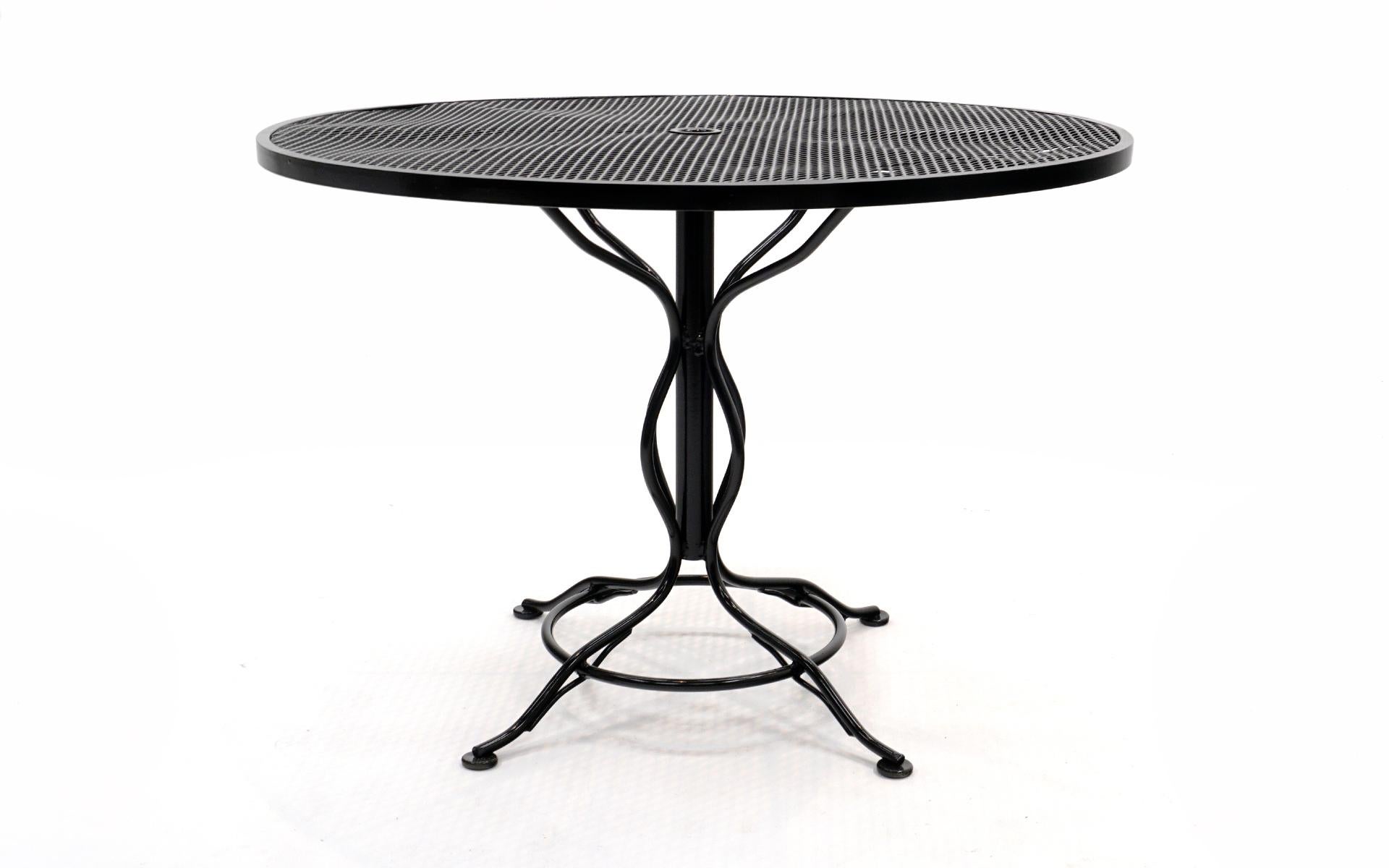 Woodard outdoor dining table professional sand blasted and painted in a black gloss automotive finish. More durable than powder coating. Beautiful detailing on the legs. Center umbrella opening.