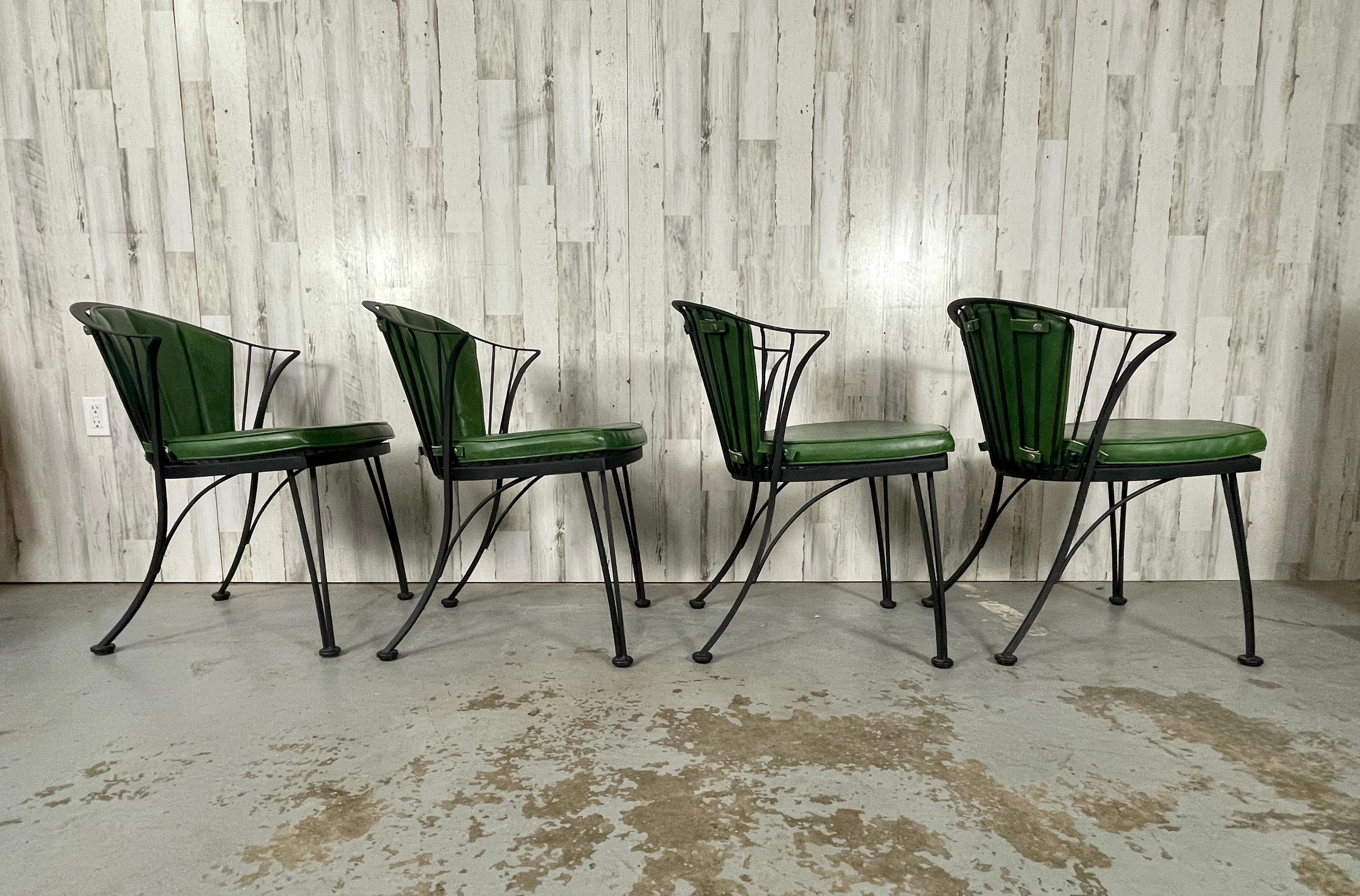  1950s wrought iron dining chairs by Woodard. The 'Pinecrest' line was one of their original designs in the 1950s. These chairs have a very attractive curved backs and legs. Faux leather green cushions give these chairs extra comfort. These chairs