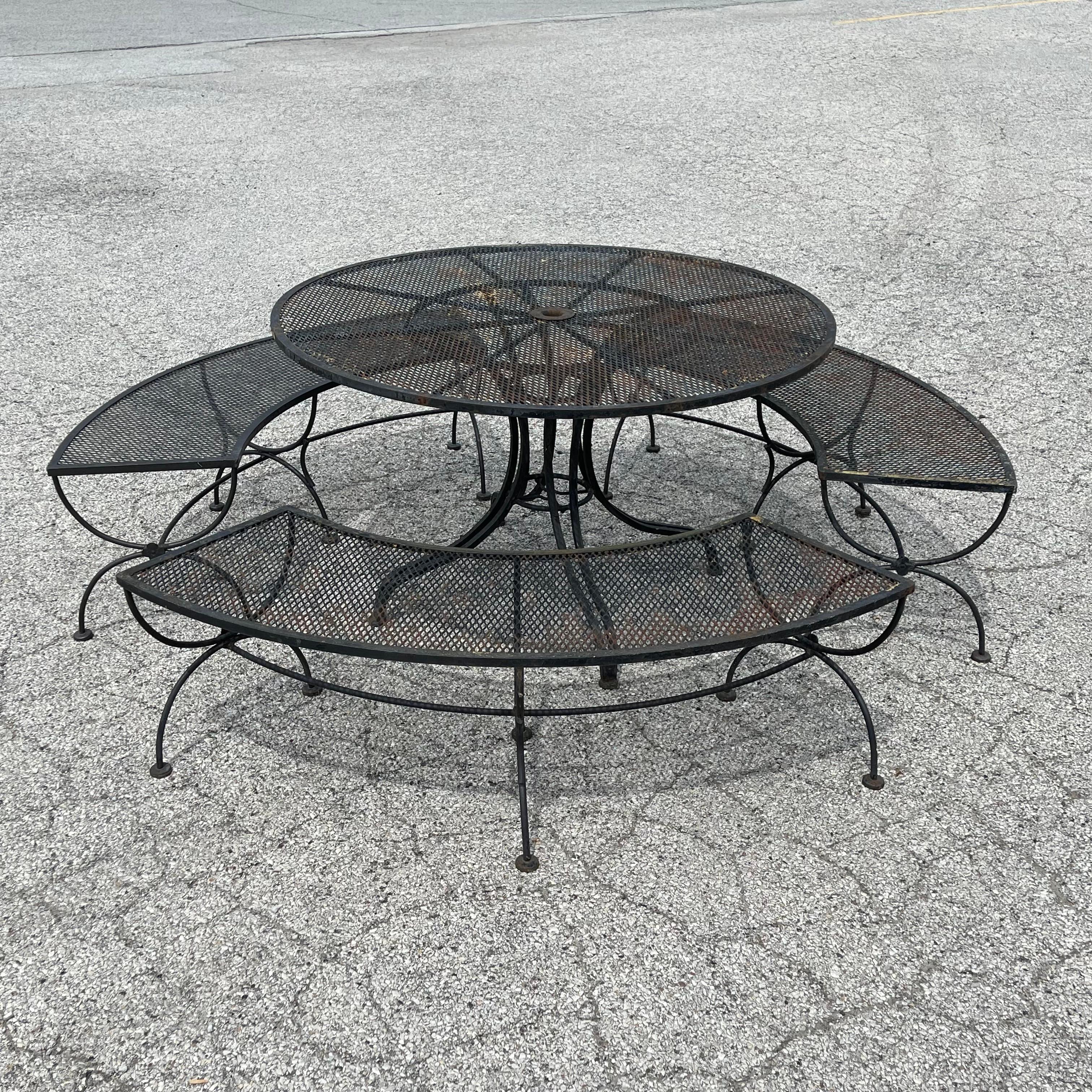 Ce superbe ensemble de patio est une pièce peu commune de Woodard. Composée d'une table de quatre pieds et de trois bancs incurvés, elle est à la fois élégante et très fonctionnelle. Les pieds sculpturaux font écho aux formes incurvées, créant ainsi