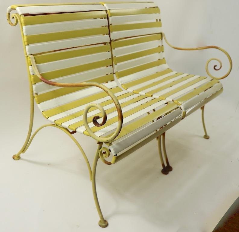 Cool Woodard settee sofa loveseat, in original condition. This example has a wrought iron scroll arm with alternating yellow and white plastic strap upholstery. Chic, stylish and fun, clean and ready to use. Please view the matching lounge chairs we